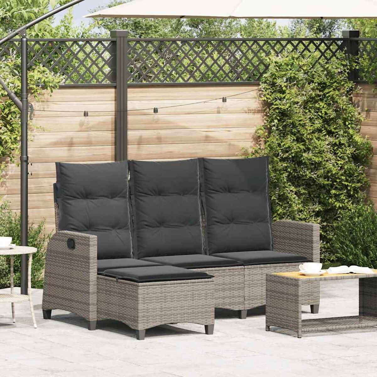 Graues Sofaset mit Tisch. Graues Sofa mit passender Fußstütze und Tisch. Outdoor-Patio-Einstellung.