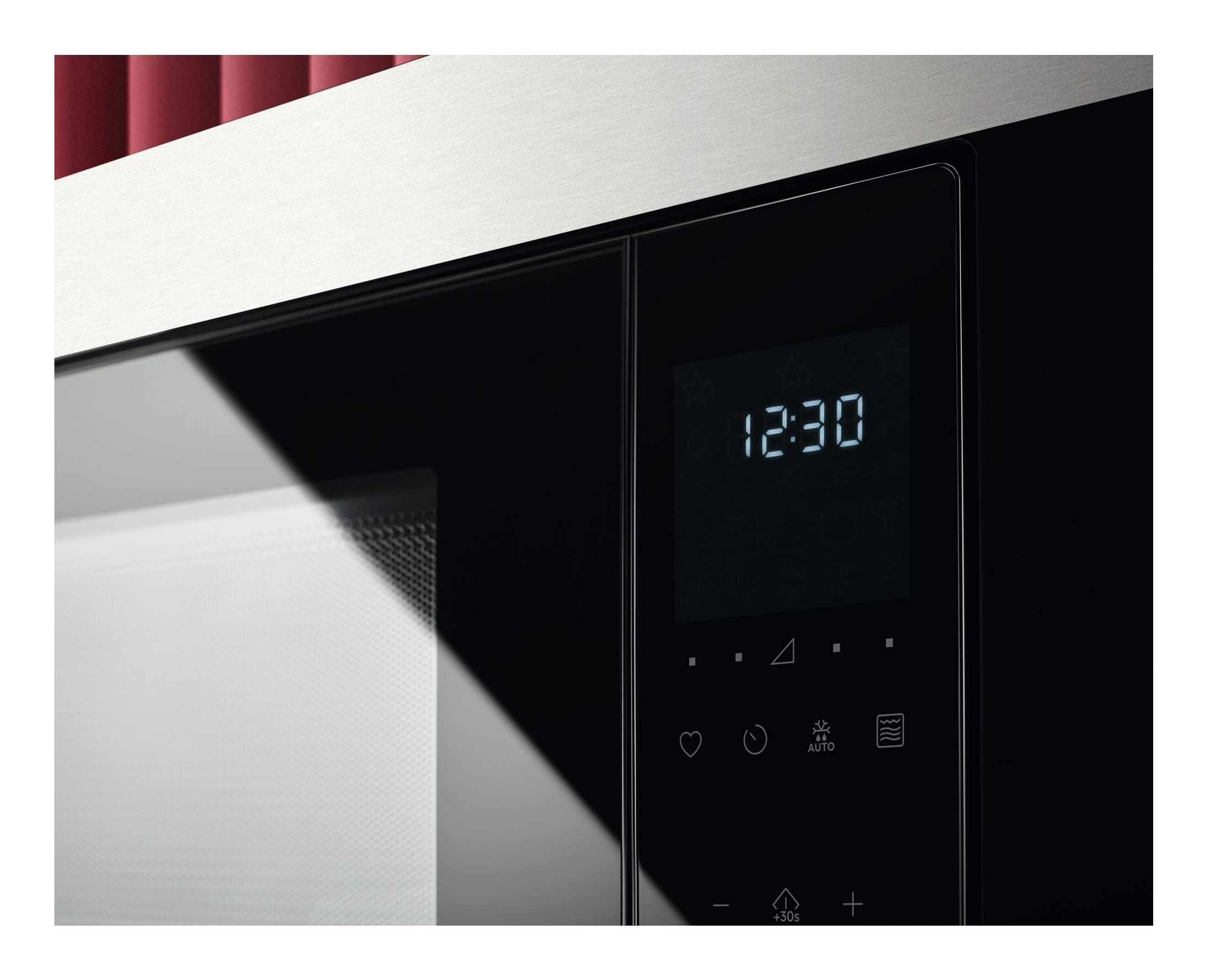 Zbliżenie panelu sterowania kuchenki mikrofalowej z cyfrowym wyświetlaczem pokazującym 12:30.