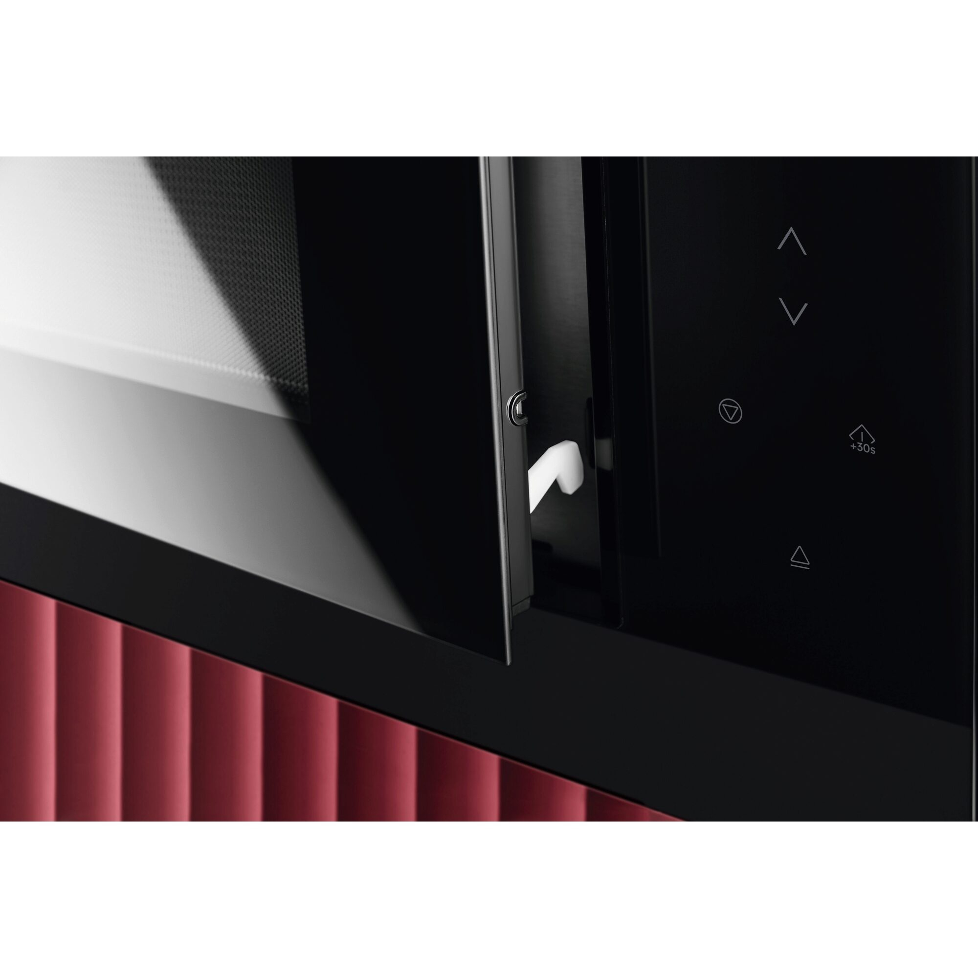 Primer plano de un horno microondas con la puerta abierta. Diseño rojo y negro.