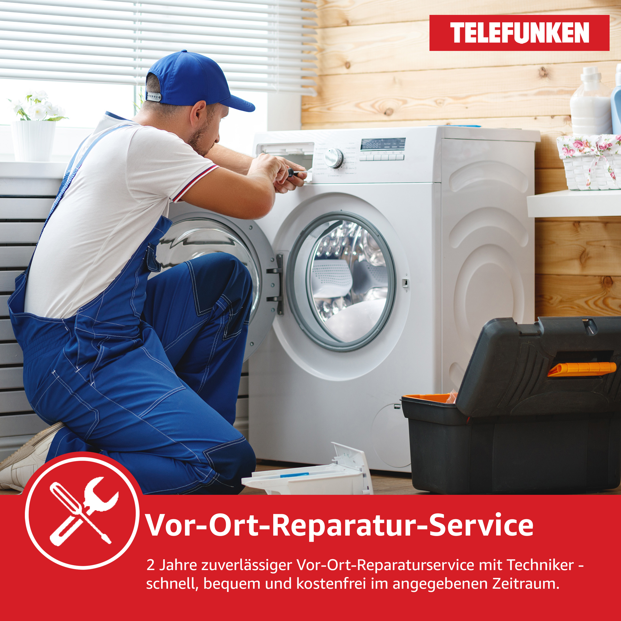 Ein Reparateur in blauen Overalls repariert eine weiße Waschmaschine. Eine schwarze Werkzeugkiste liegt auf dem Boden.