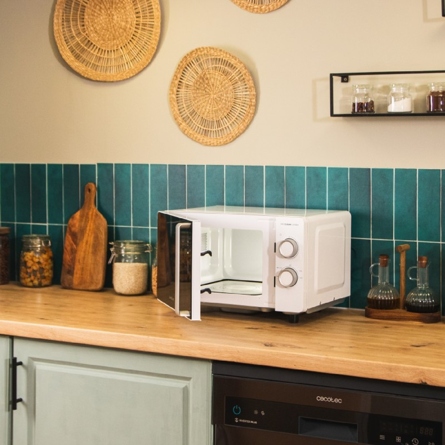 Biała kuchenka mikrofalowa z otwartymi drzwiami, ustawiona na blacie z elementami kuchni w tle.