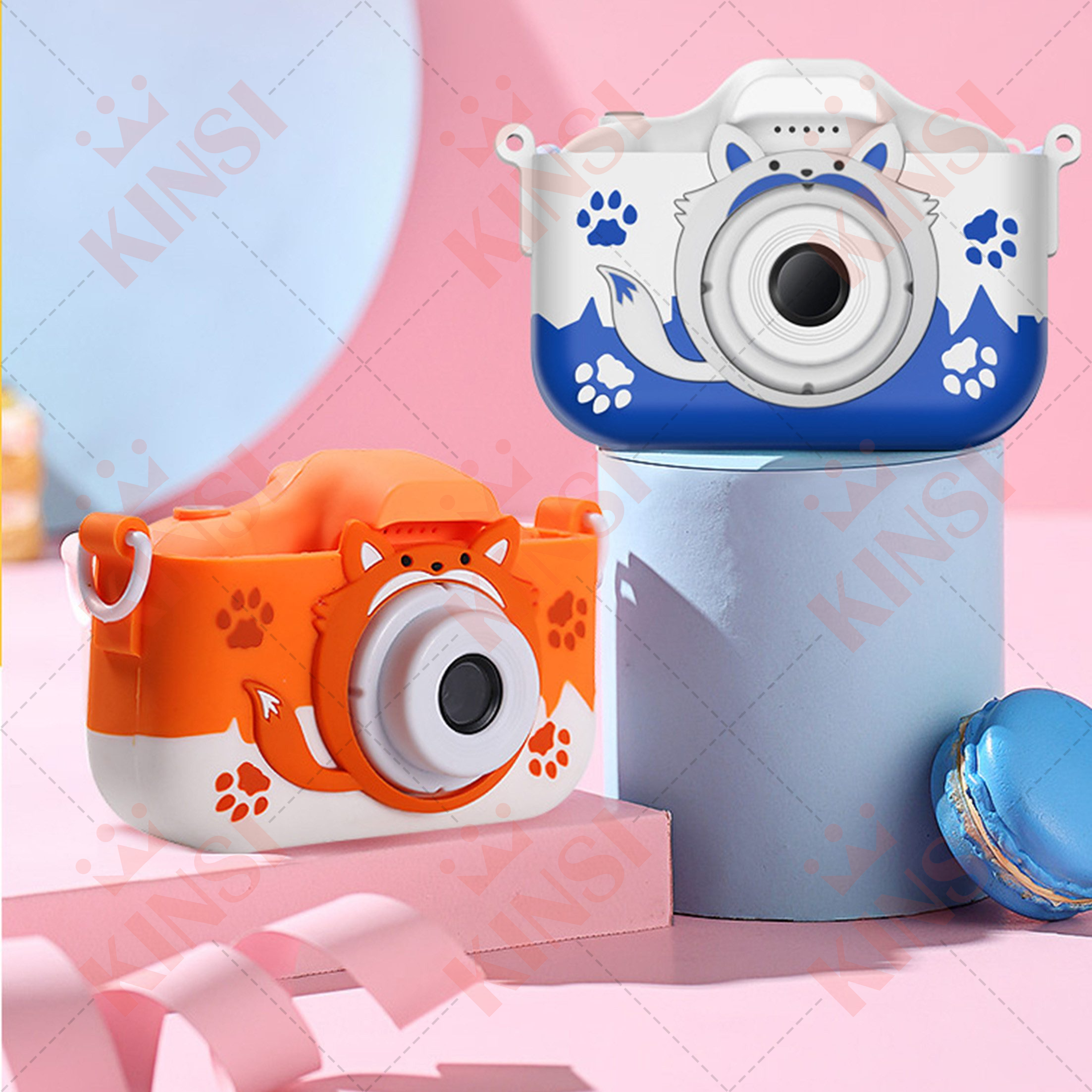 Zwei Spielzeugkameras, eine orange und eine weiße. Beide haben süße Fuchsgesichter. Blauer und rosa Hintergrund.