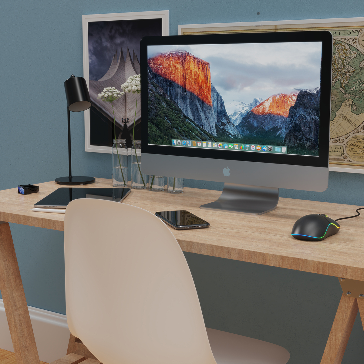Office desk with a computer, monitor, phone, and chair. There is a lamp and plants.