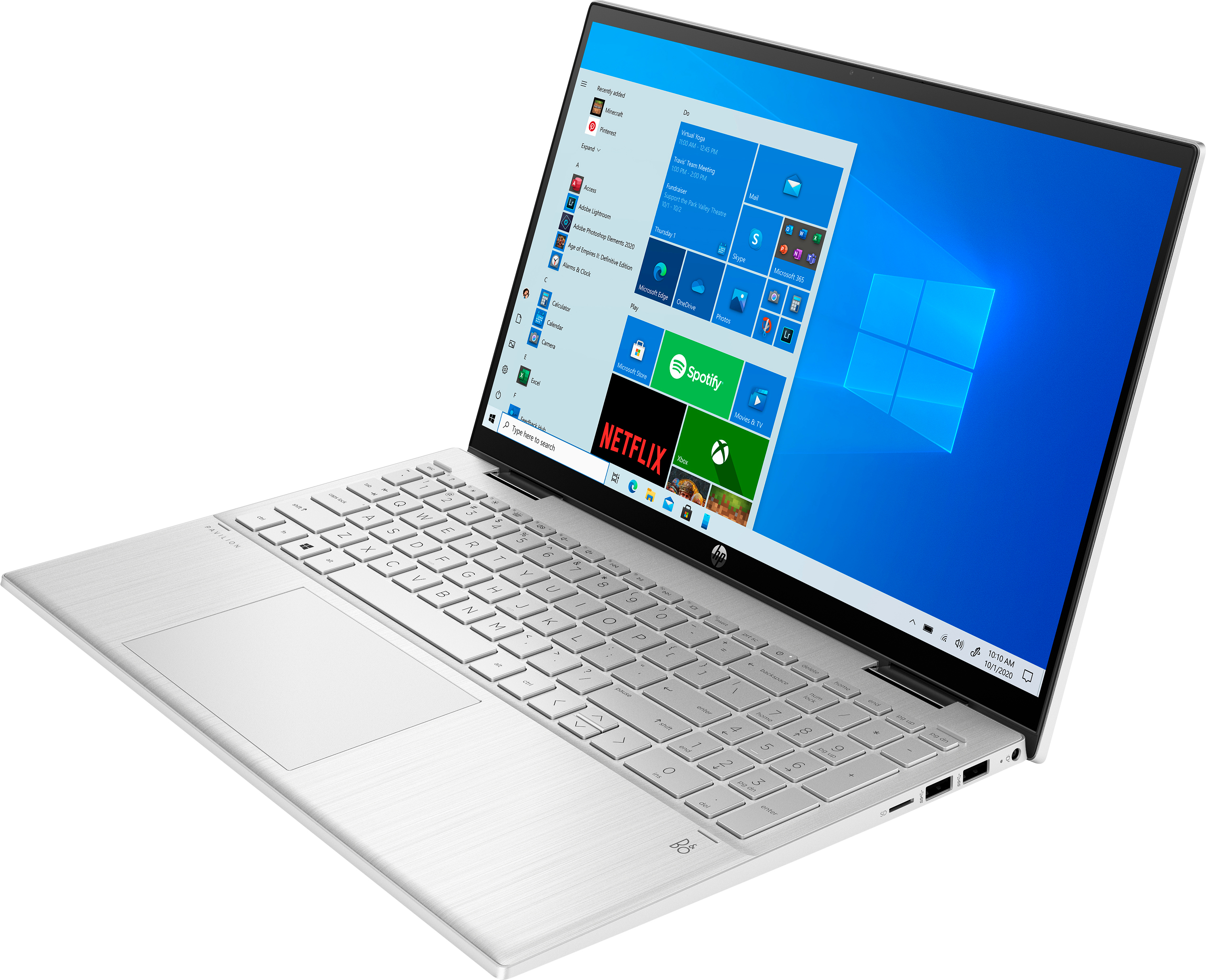 Silberner Laptop mit Windows-Anzeige. Tastatur und Trackpad sichtbar. Der Bildschirm zeigt Apps wie Spotify.