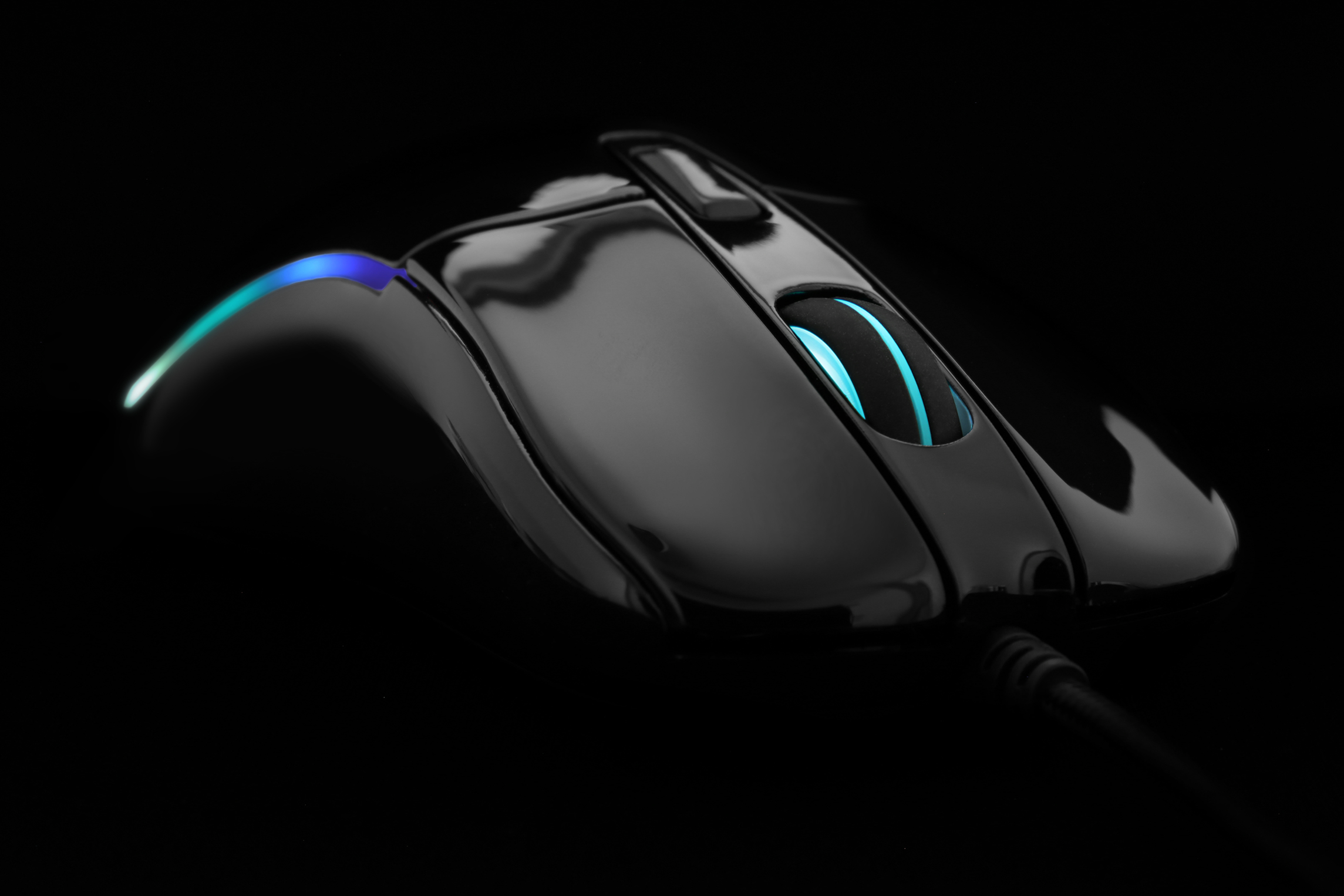 Eine schwarze Gaming-Maus mit blauer und tealfarbener Beleuchtung vor schwarzem Hintergrund.