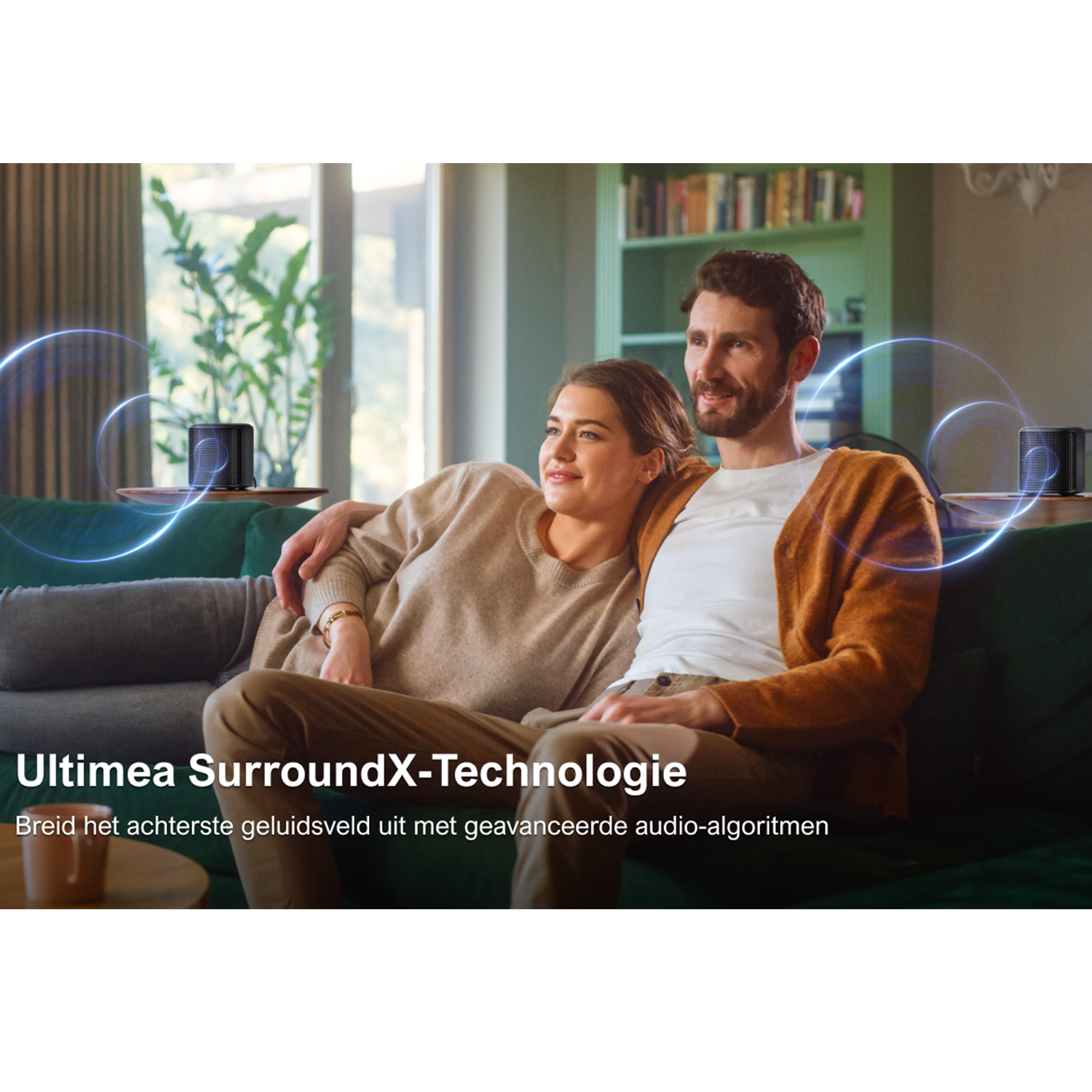 Couple on a sofa. Speakers are on the sides. Text in Dutch.