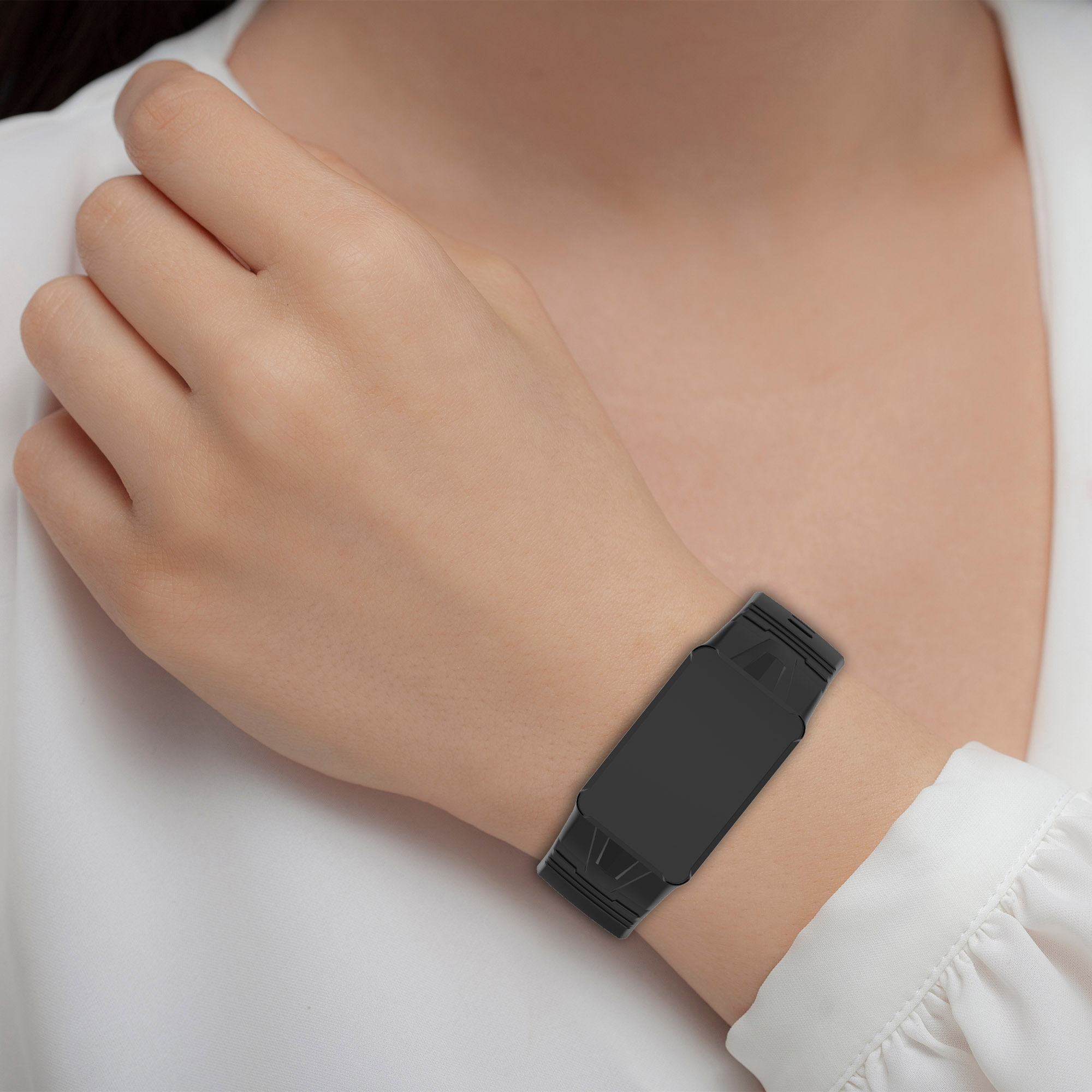 Un polso con un fitness tracker nero. Il tracker è rettangolare e ha un cinturino nero.