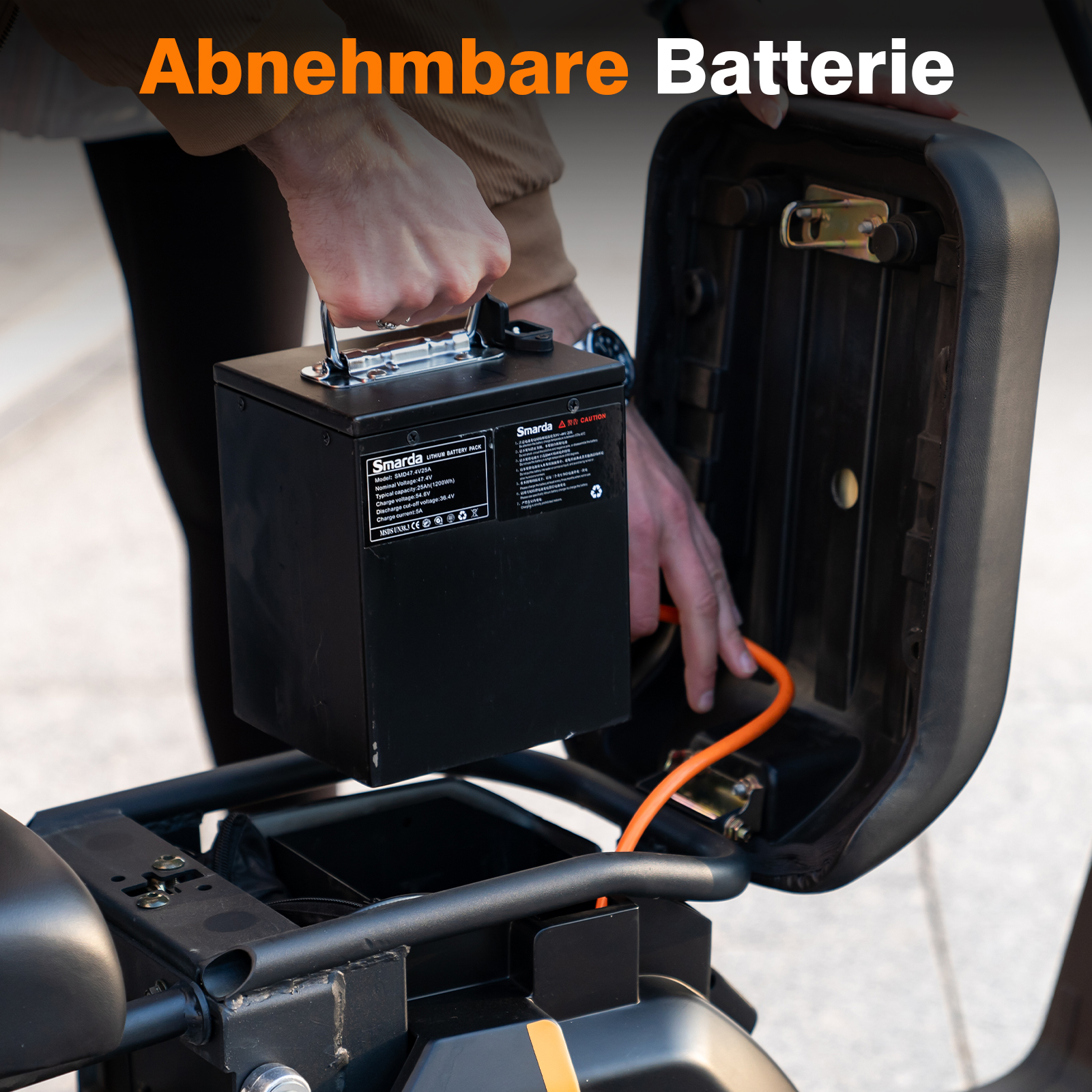 Eine Person, die eine schwarze Batterie aus einem Roller entfernt. Die Batterie befindet sich in einem Fach.