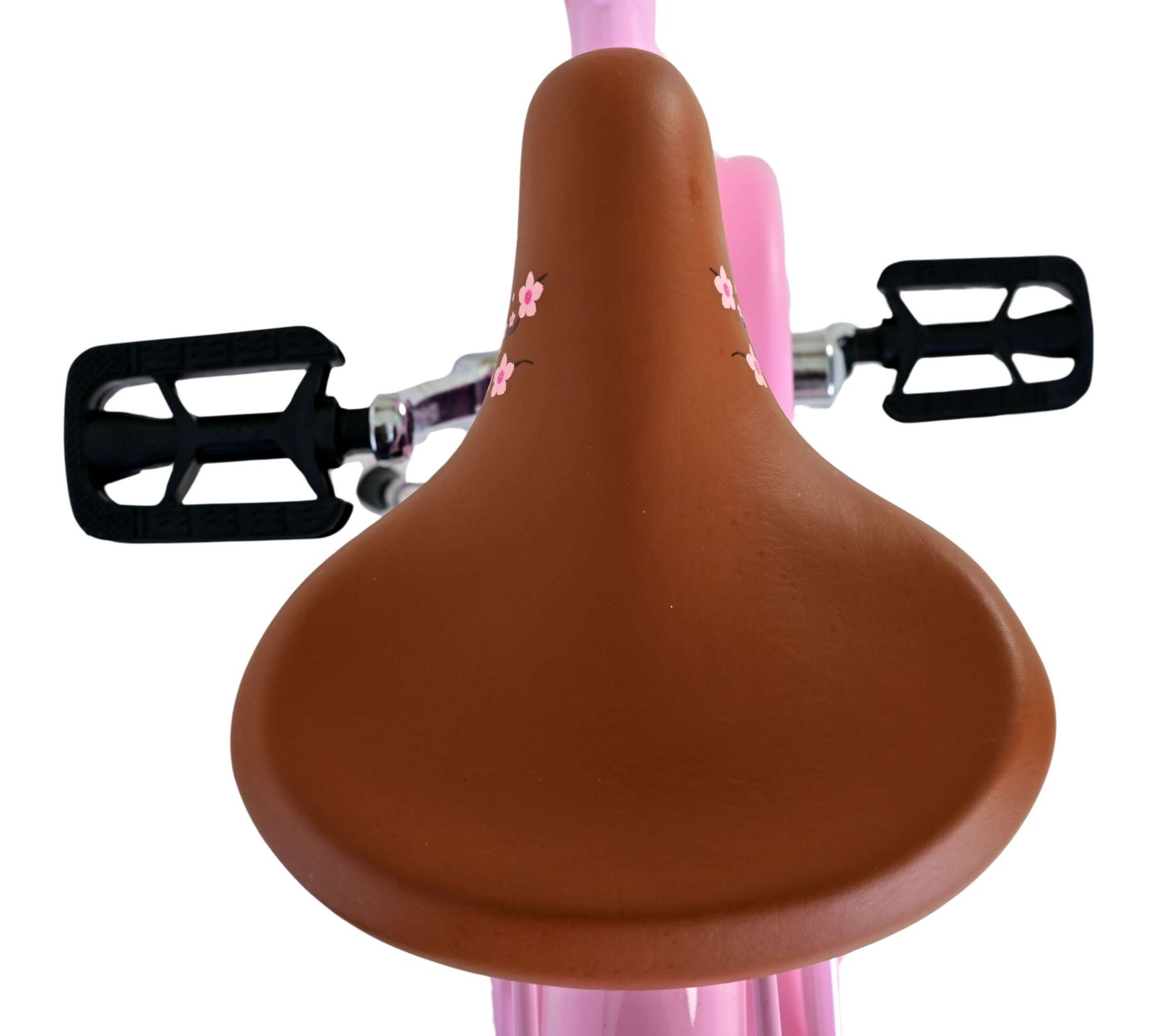 Brauner Fahrradsattel mit rosa Blüten. Schwarze Pedale an beiden Seiten. Weißer Hintergrund.