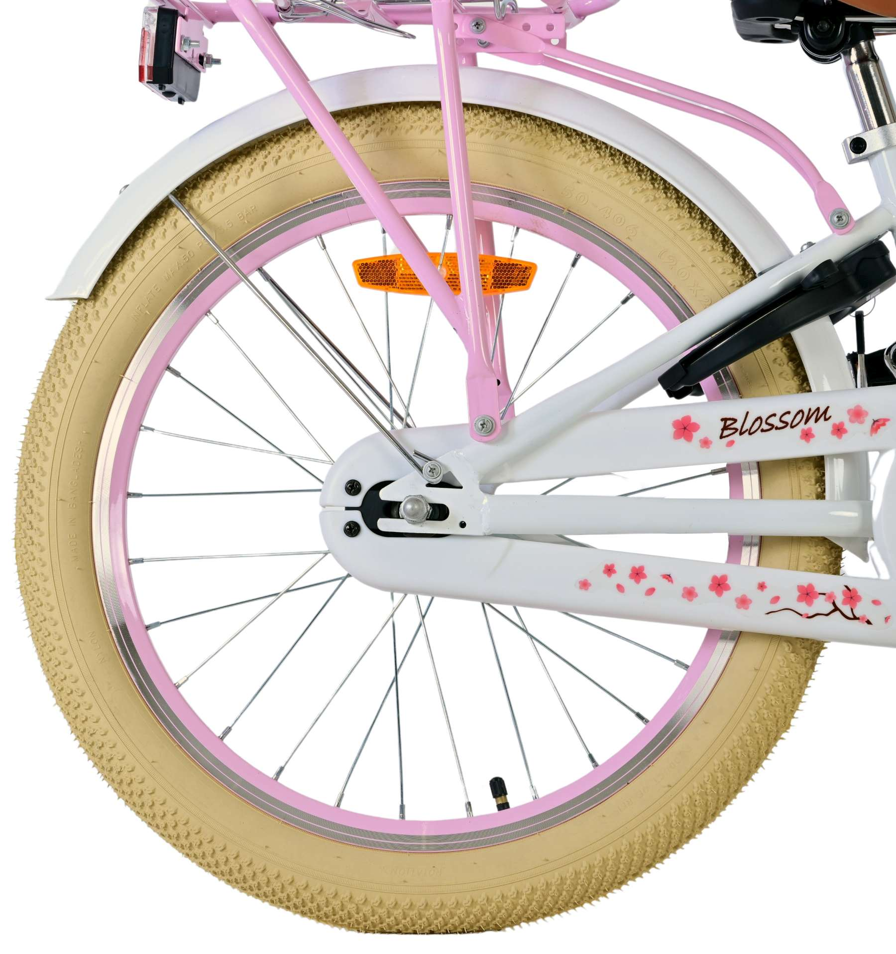Nahaufnahme eines weißen und rosa Fahrradrads. Der Reifen ist beige. Das Wort 'Blossom' steht auf dem Rahmen.