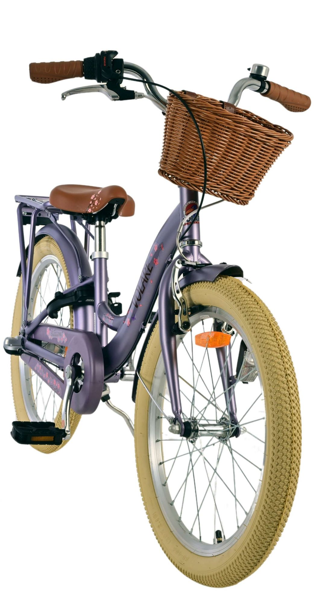 Una bicicleta morada para niños con cesta de mimbre y llantas beige.