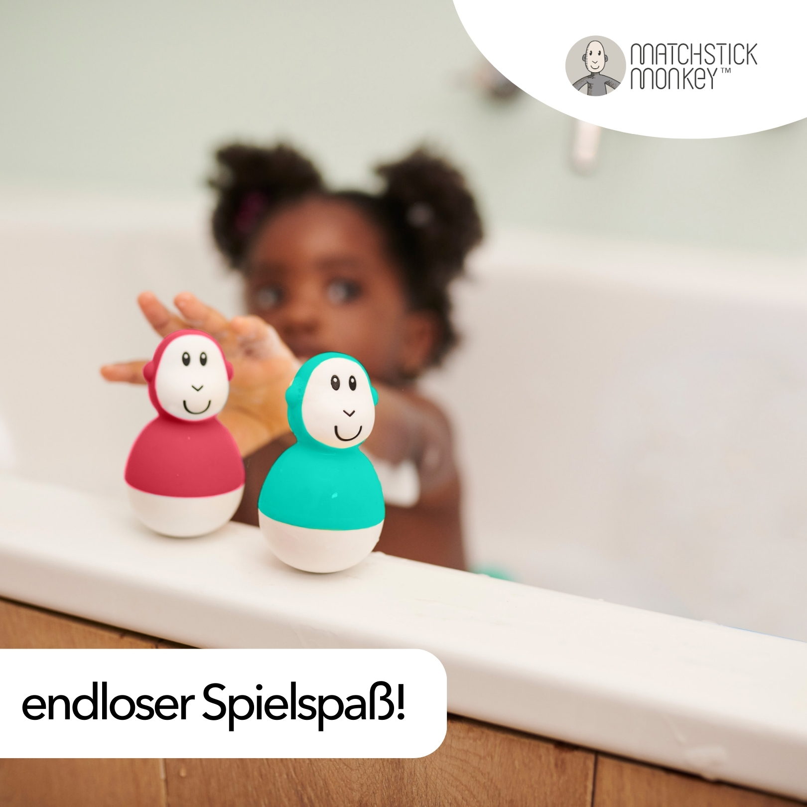 Zwei Spielzeug-Affen in einer Badewanne. Einer rot, einer türkis, Kind im Hintergrund.