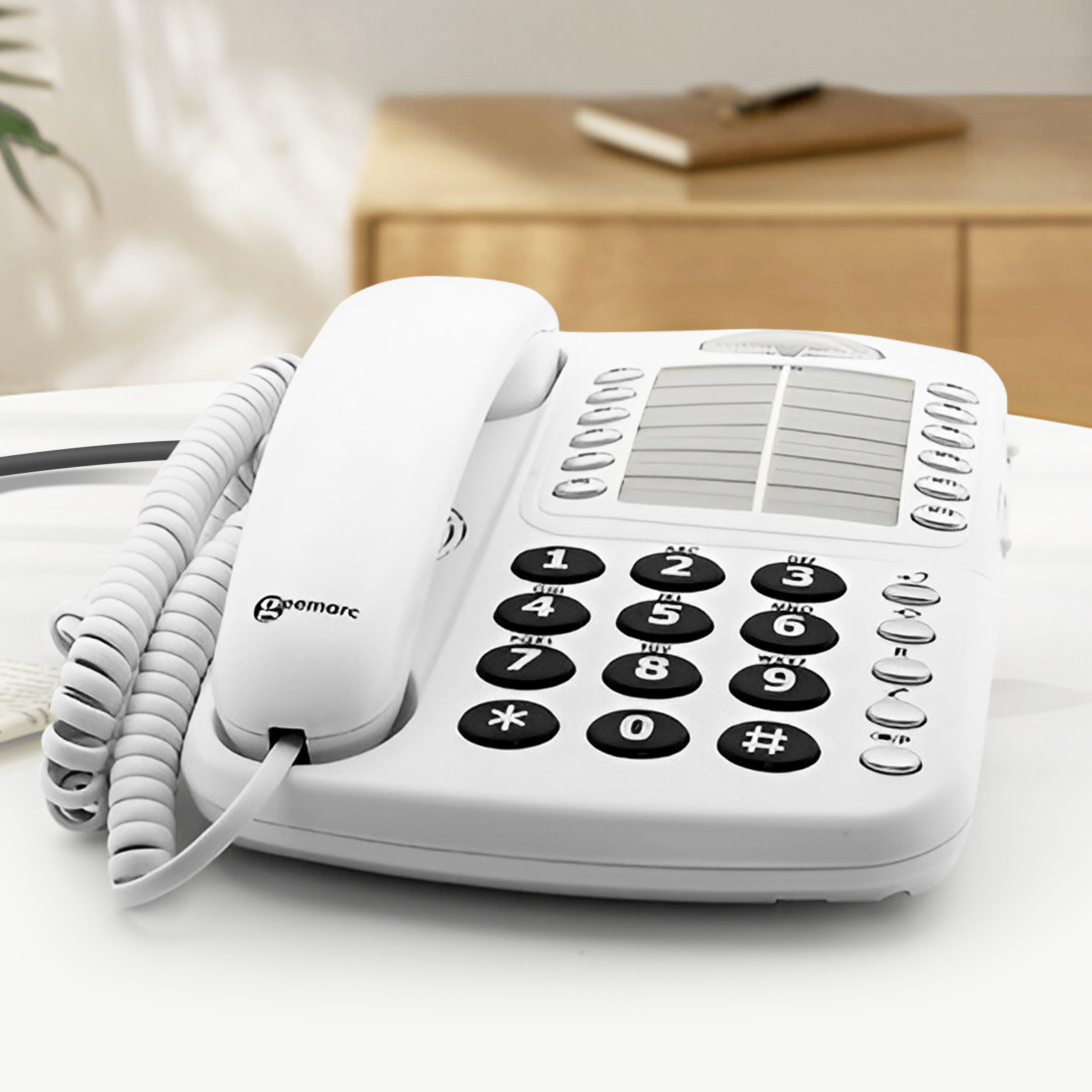 Weißes Festnetztelefon auf weißem Tisch. Die Zifferntasten sind groß.