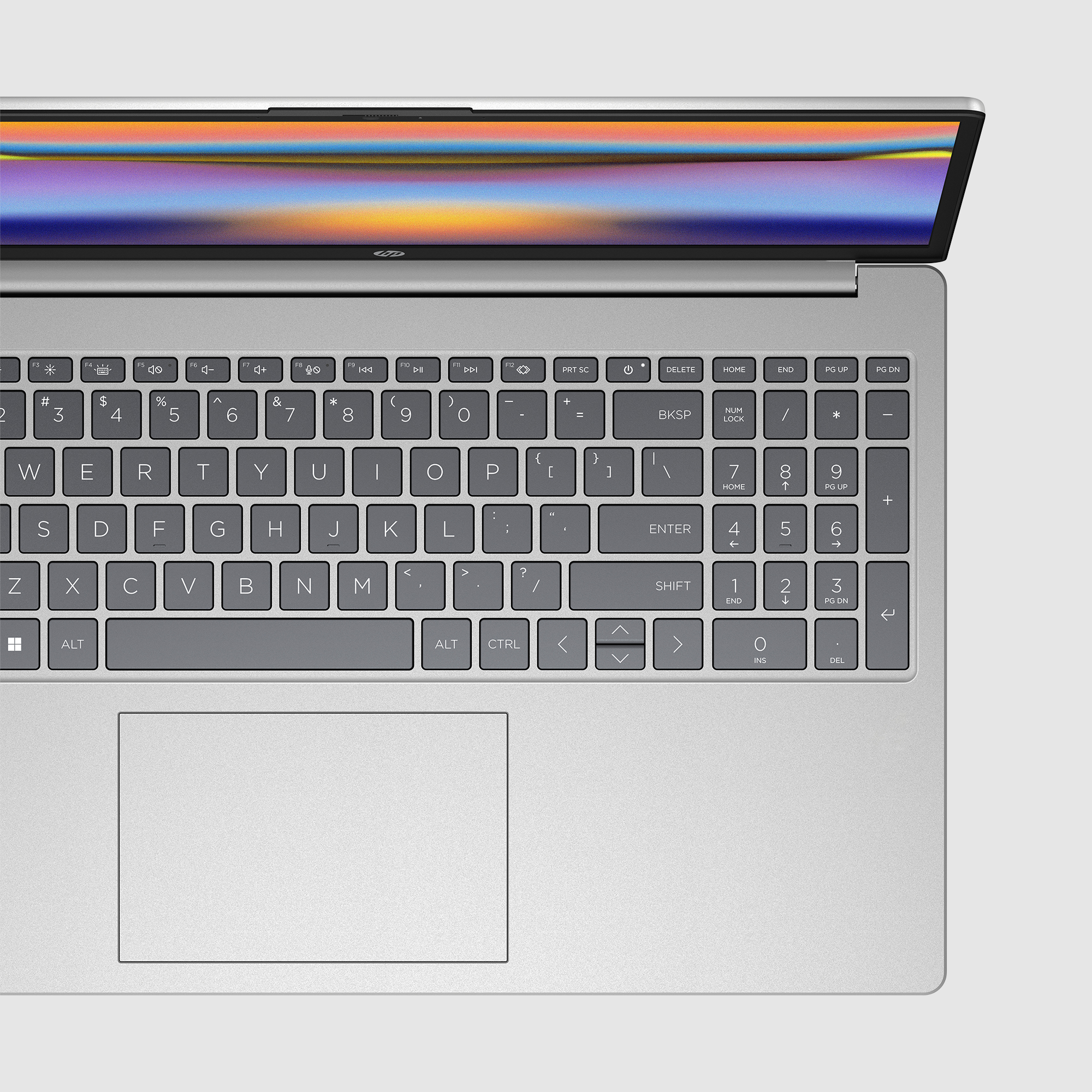 Klawiatura i ekran laptopa. Klawiatura jest srebrna z panelem dotykowym. Ekran wyświetla kolorowy obraz.