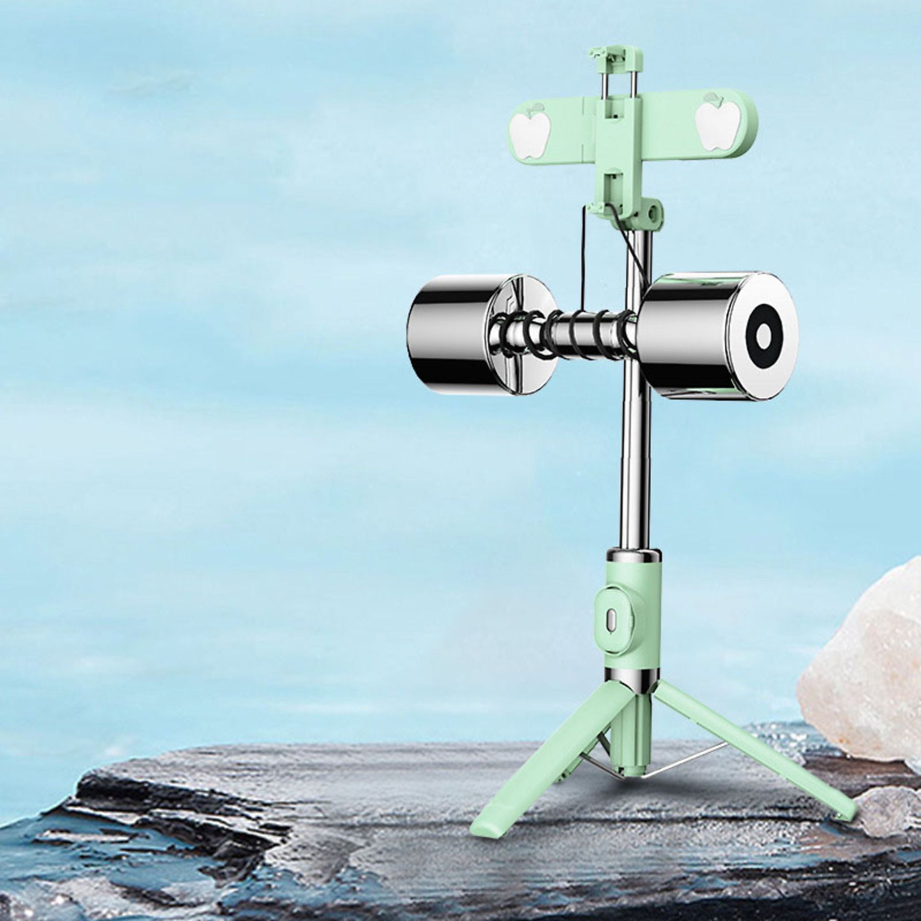 Ein Selfie-Stick mit Handyhalter und Lichtern, auf einem mintgrünen Ständer, vor blauem Hintergrund.