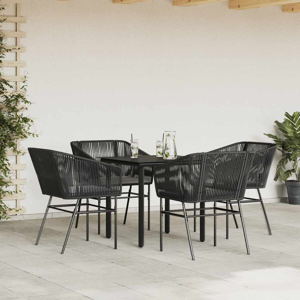 Terrassenset, schwarze Stühle und Tisch mit Getränken, auf hellem Steinboden.