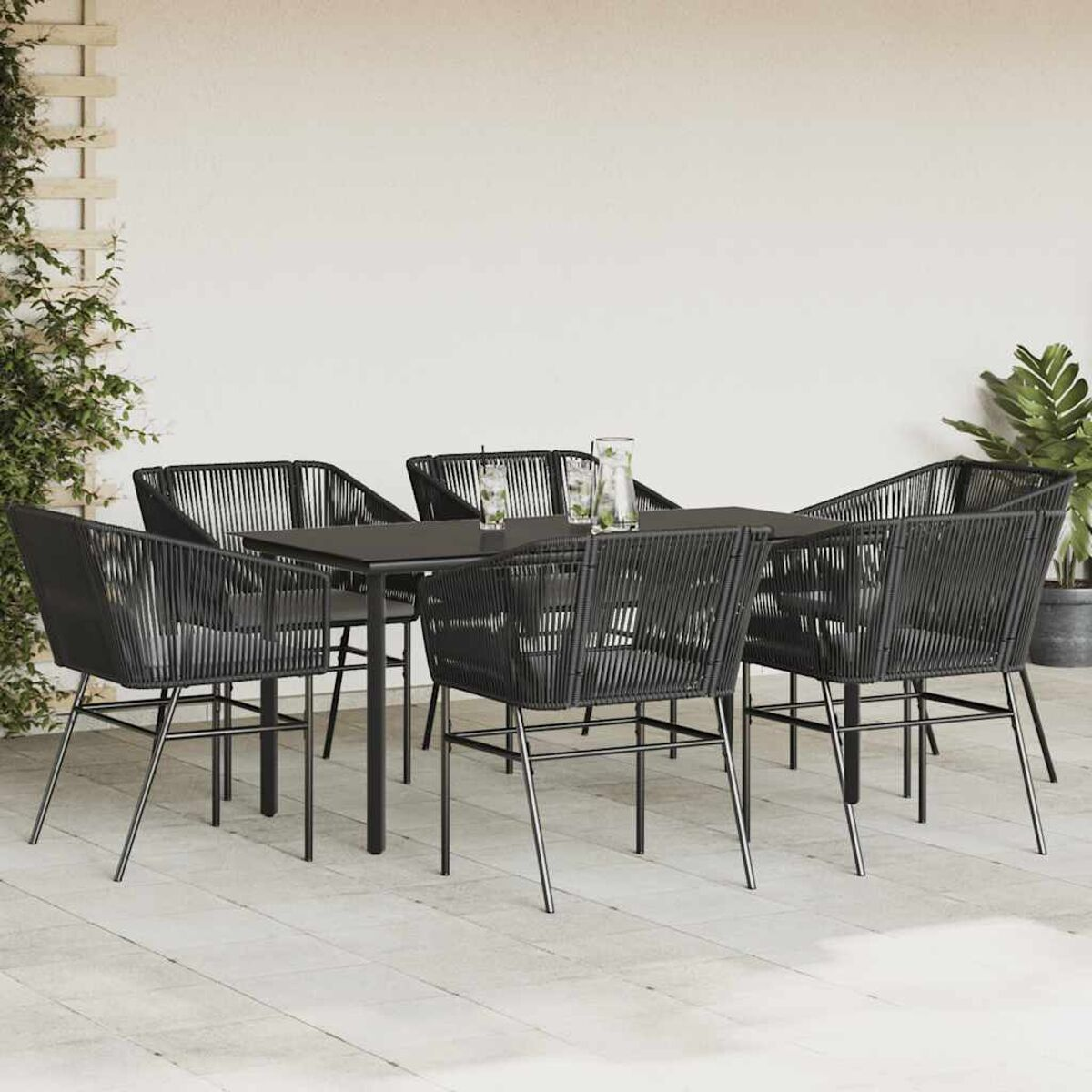 Essgruppe für den Außenbereich mit einem schwarzen Tisch und sechs schwarzen Stühlen. Auf einer Terrasse.