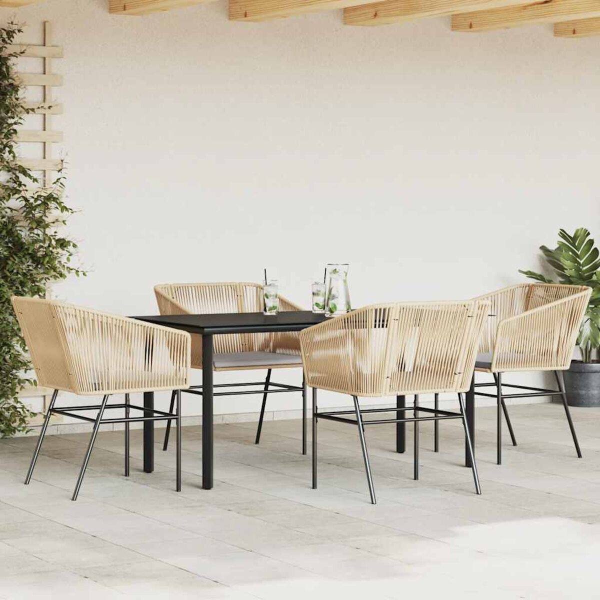 Essgruppe im Freien mit einem Tisch und vier Stühlen. Die Stühle haben gewebte Rücken und Sitze.