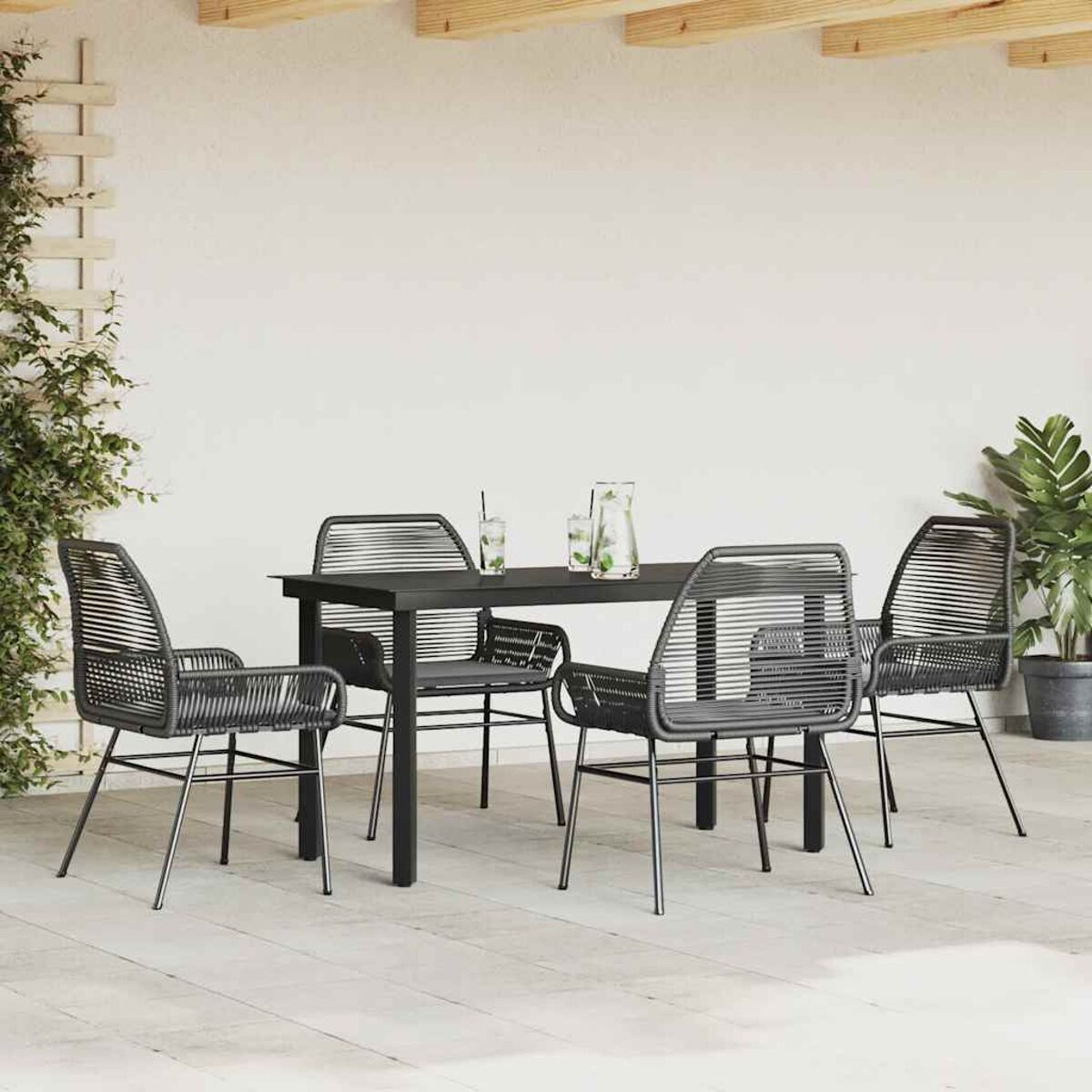 Juego de comedor al aire libre con mesa y sillas negras en un patio.