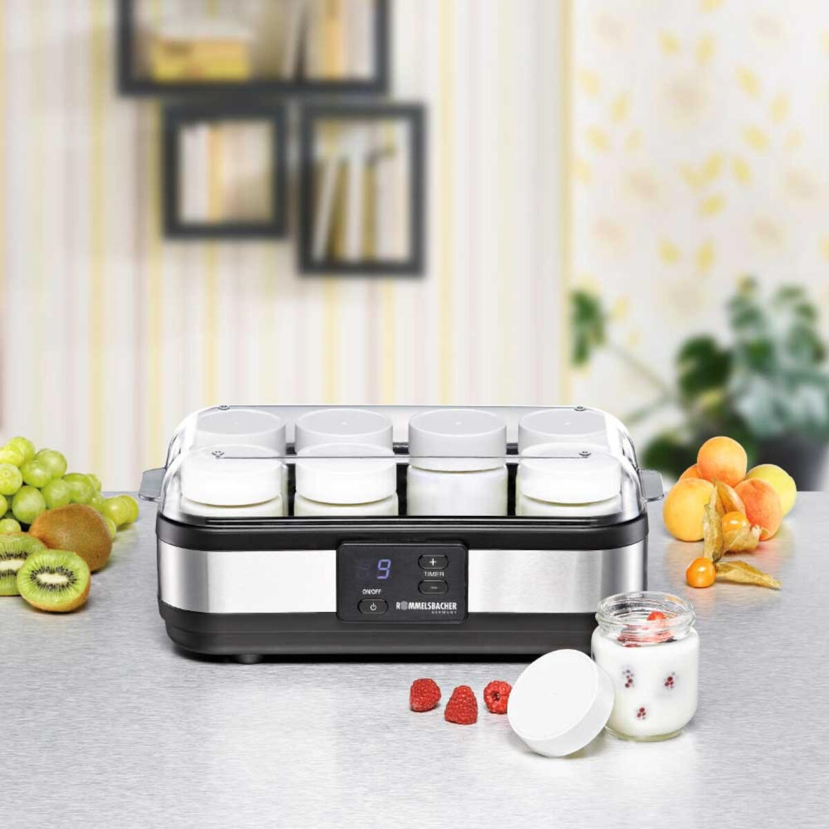 Joghurtbereiter mit Gläsern, Obst und Display auf einem Tisch.