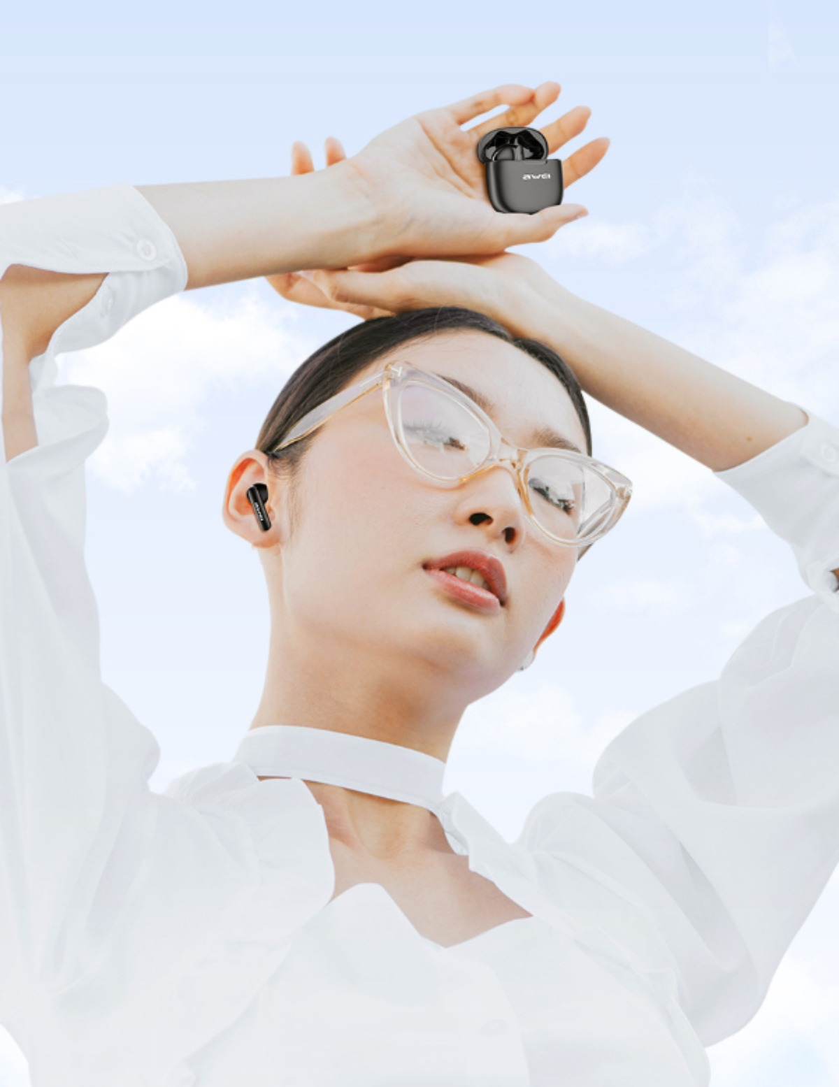 Frau hält Ohrhörer in der Hand. Sie trägt eine Brille und ein weißes Oberteil. Himmel im Hintergrund.