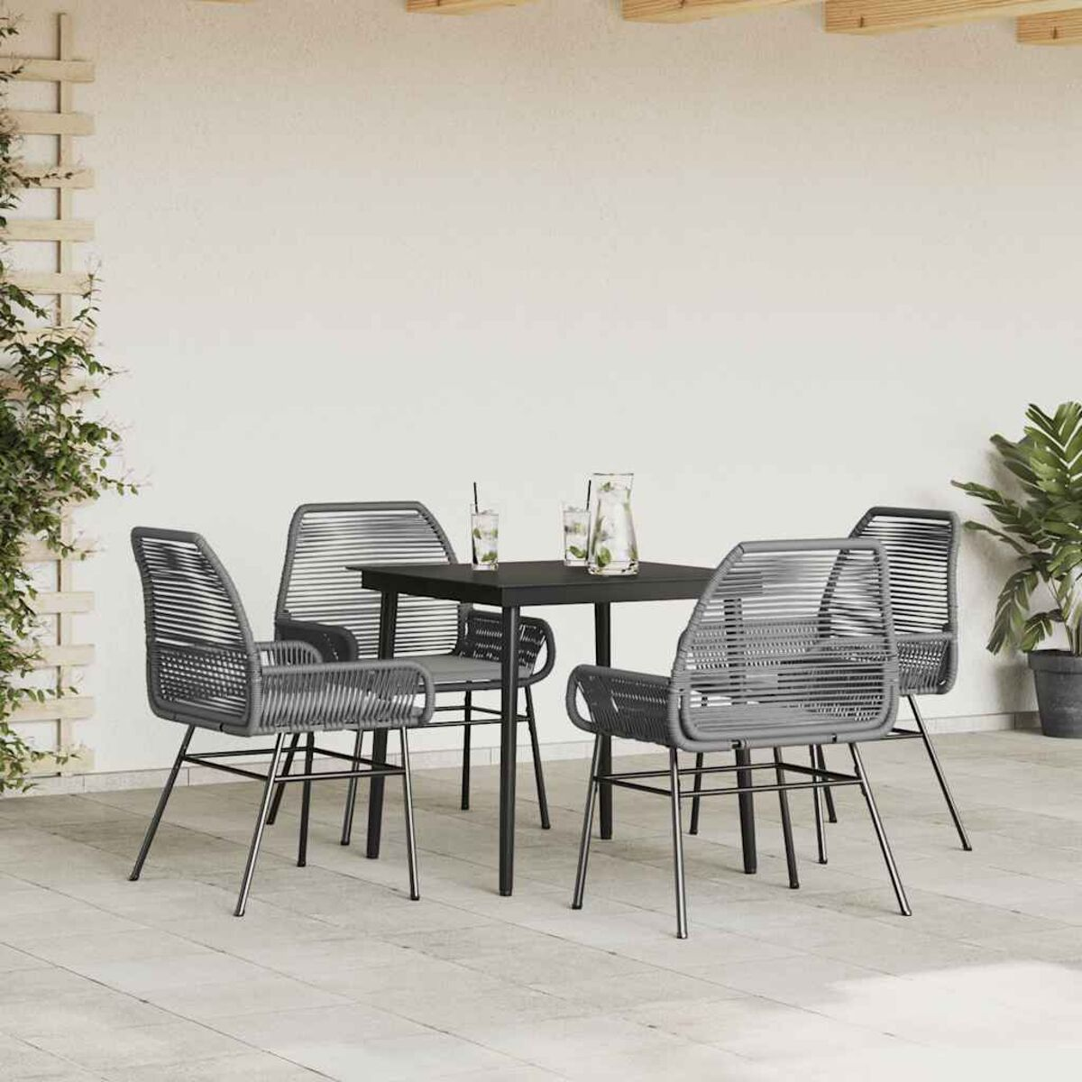 Set di mobili da esterno. Quattro sedie grigie e un tavolo nero su un patio.