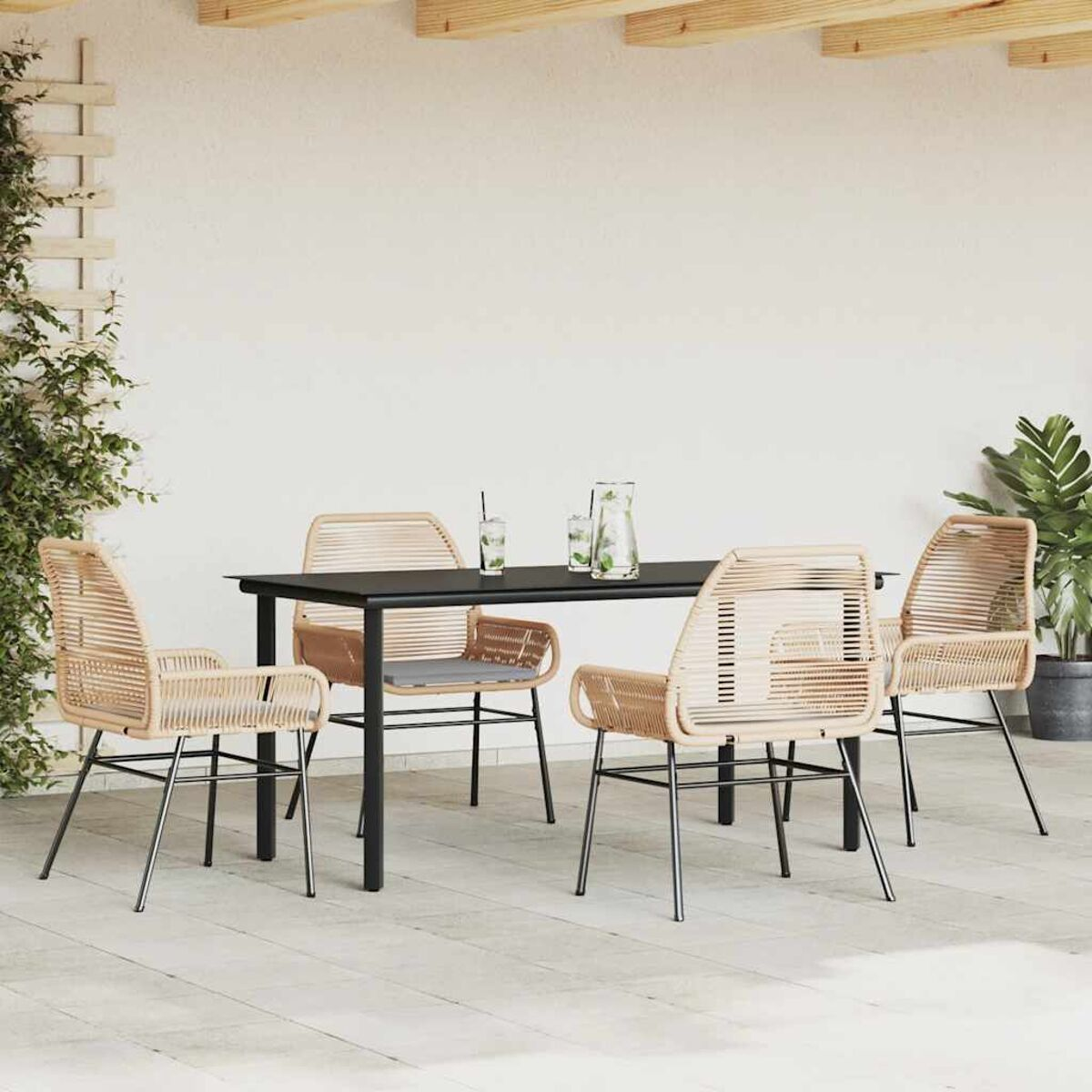 Set da pranzo all'aperto con tavolo nero e sedie beige intrecciate.