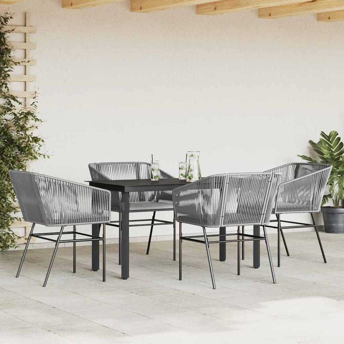 Essgruppe im Freien mit vier grauen Stühlen und einem schwarzen Tisch, auf der Terrasse aufgestellt.