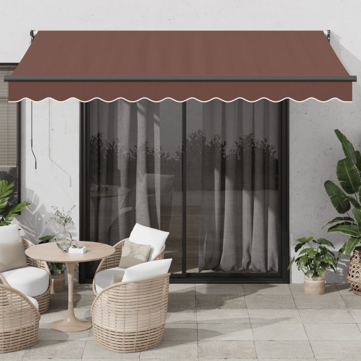 Una tenda da sole marrone sopra una porta scorrevole in vetro, con finiture bianche e un set da patio davanti.