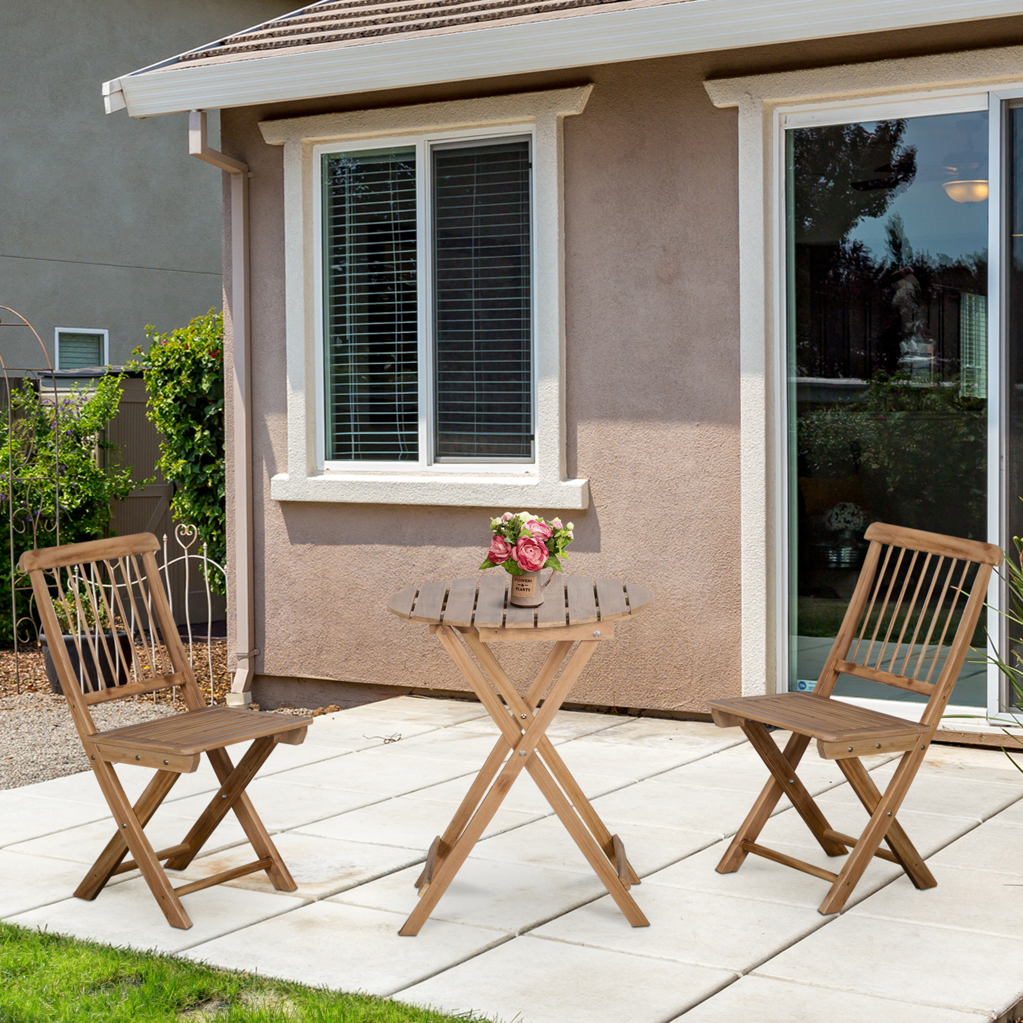Terrassenset im Freien mit einem Holztisch und zwei Holzstühlen. Die Terrasse hat einen Haus-Hintergrund.