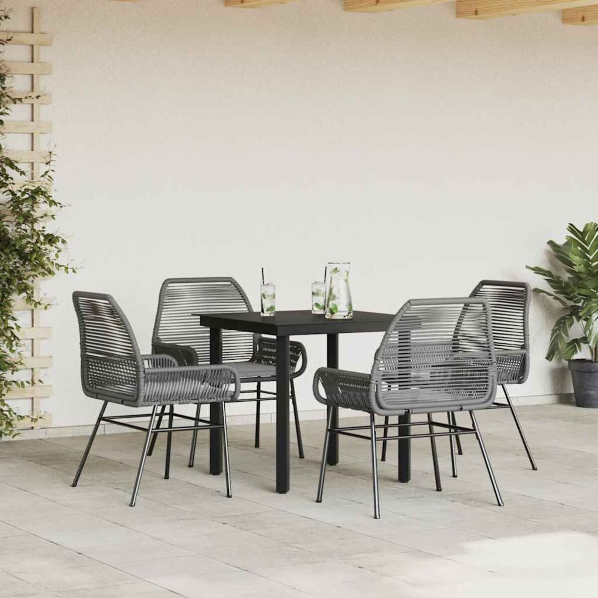 Ein Ess-Set mit vier grauen gewebten Stühlen, einem schwarzen Tisch und Getränken, auf einer Terrasse mit einer Pflanze.