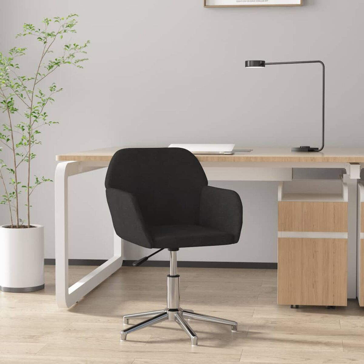 Schwarzer Bürostuhl, Schreibtisch mit Laptop und Pflanze, neutraler Hintergrund.