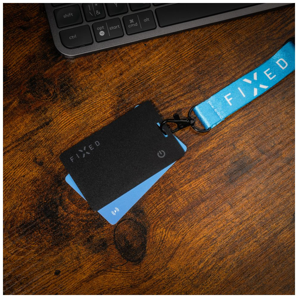 Schreibtisch mit Tastatur, zwei Karten, eine blau. Ein Schlüsselband rechts, 'FIXED'.