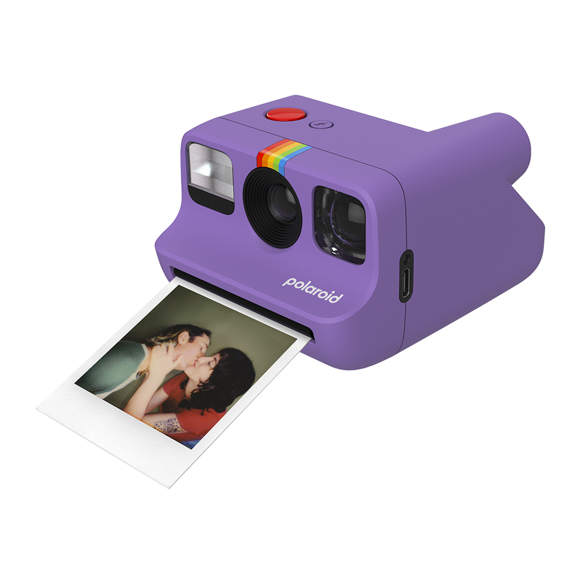 Una cámara Polaroid morada con una imagen de dos personas besándose mientras se imprime.