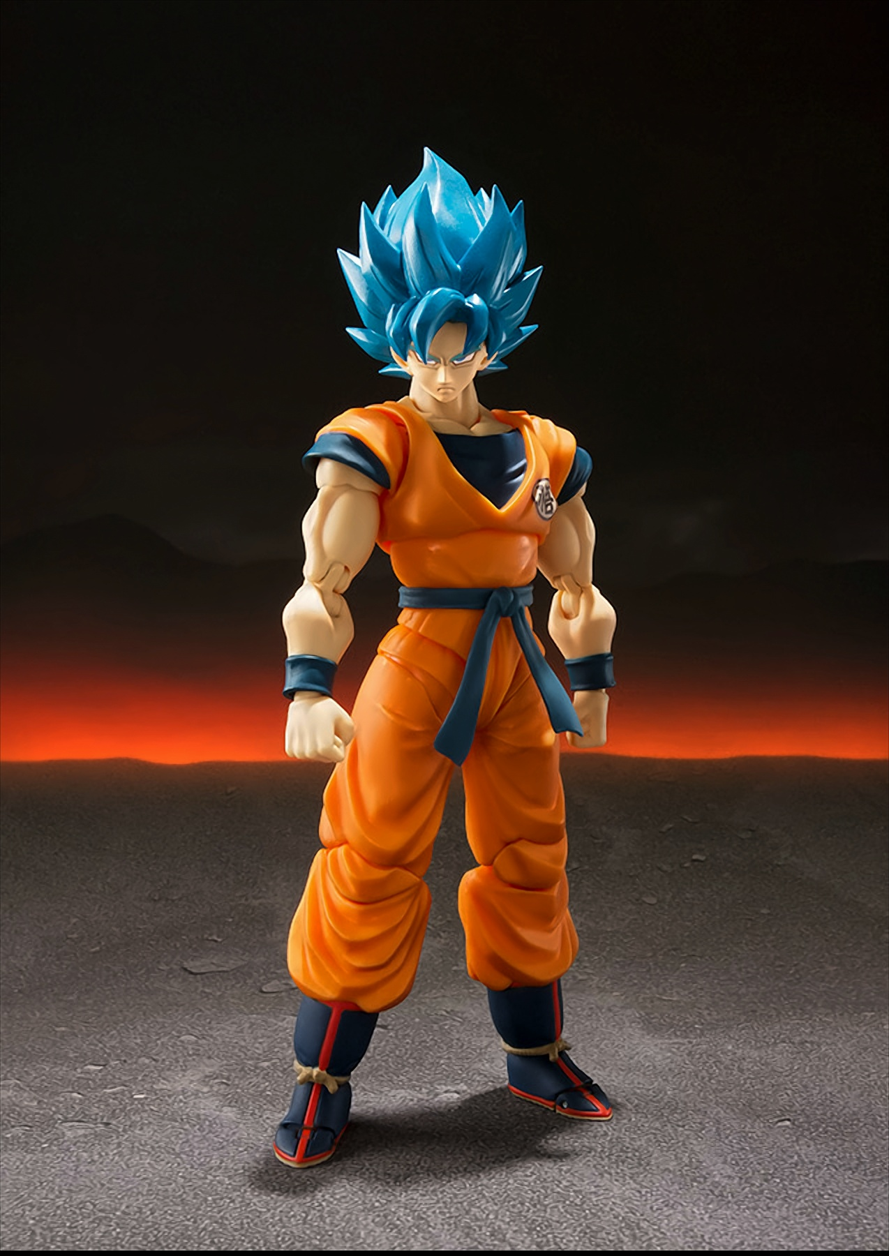 Anime-Figur von Goku in Orange und Blau, auf grauer Oberfläche mit rotem Hintergrund.