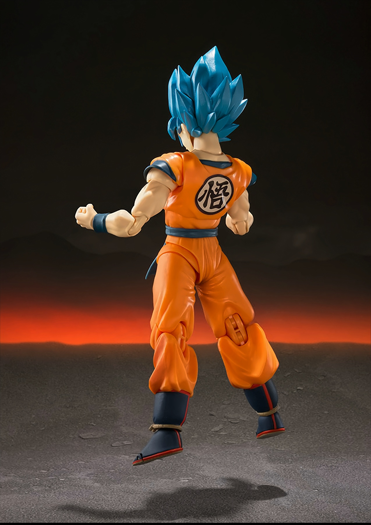 Eine Dragon Ball Z-Figur mit blauen Haaren. Er trägt eine orangefarbene Uniform und ist in Kampfpose.
