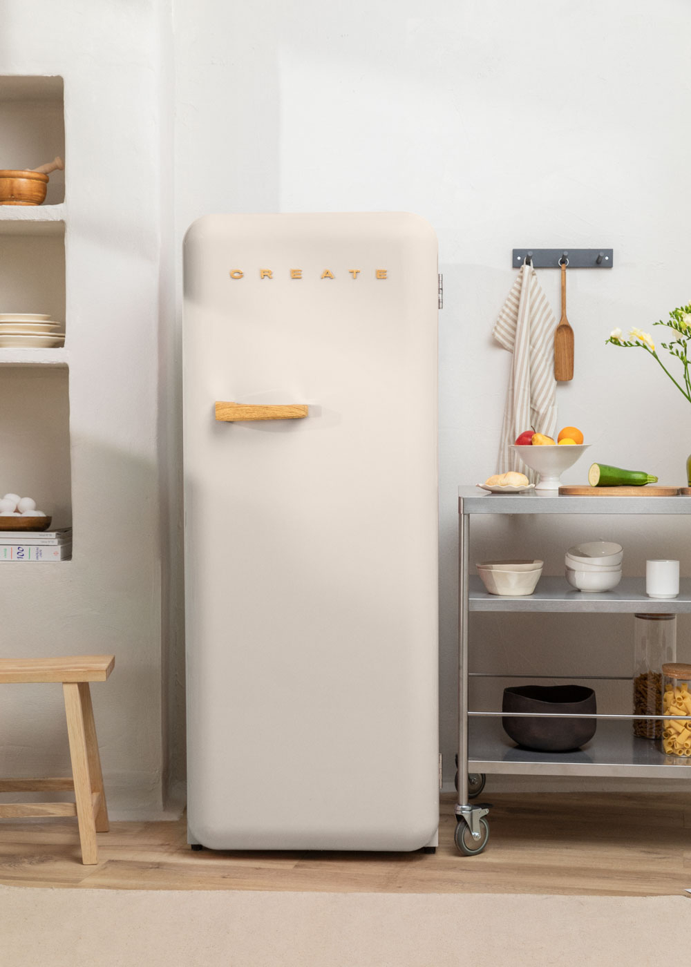 Refrigerador color crema en un entorno de cocina, con detalles de madera y letras CREATE.