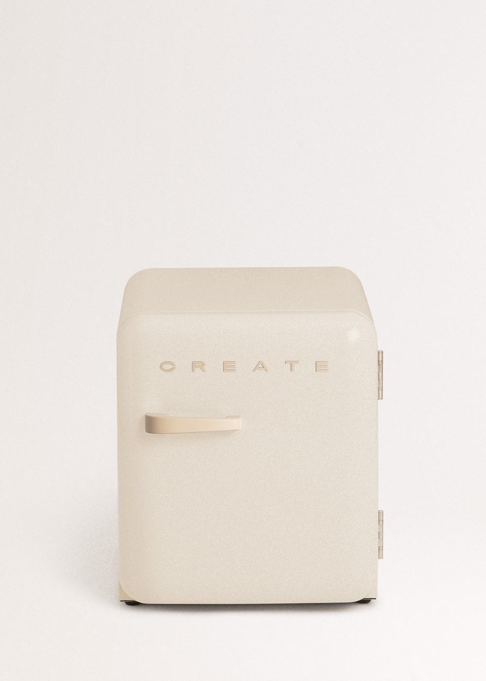 Pequeño refrigerador retro beige con texto CREATE. Un mango de madera está en el costado.