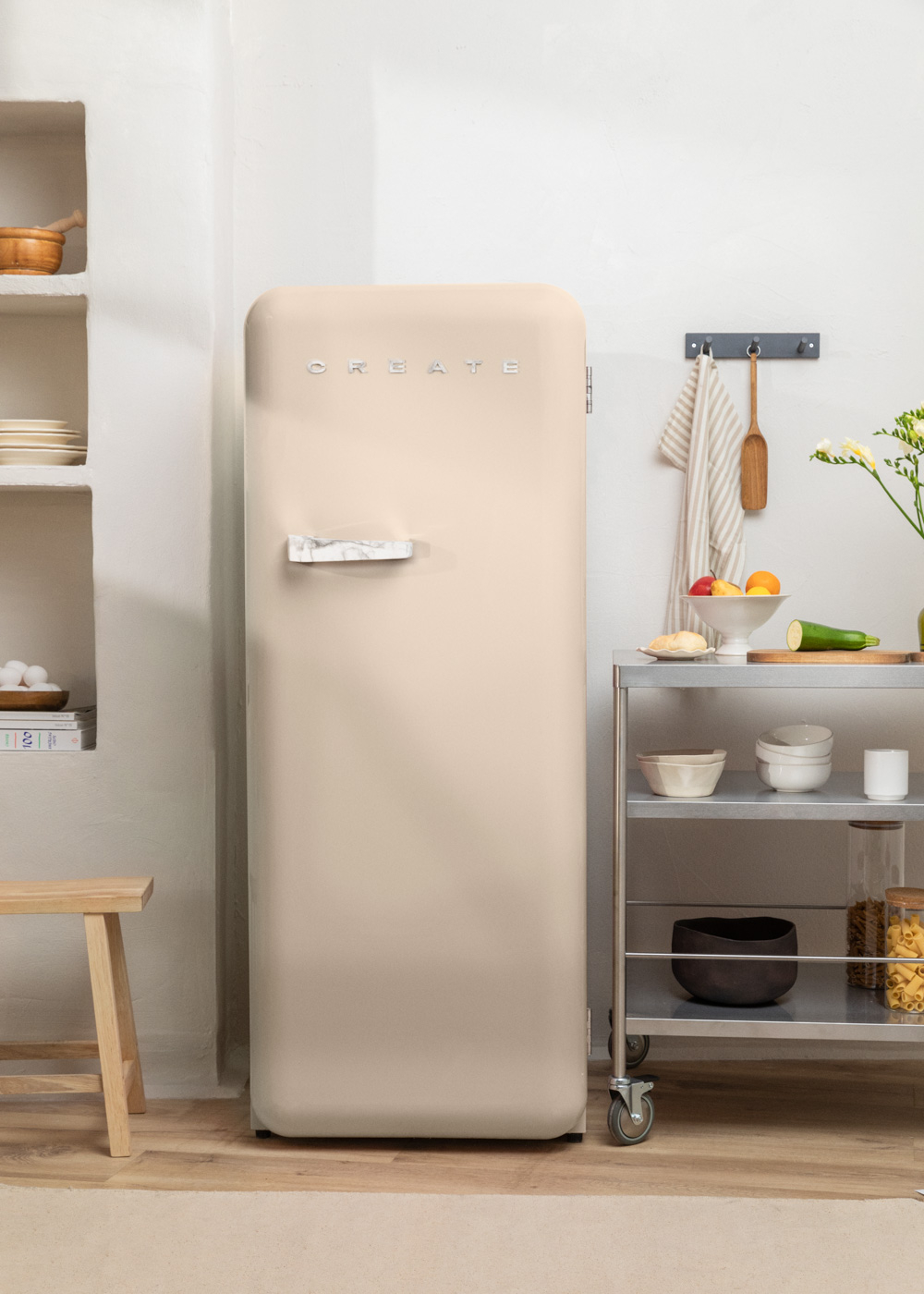 Un refrigerador Create beige en un entorno de cocina, con estantes y un carrito cerca.