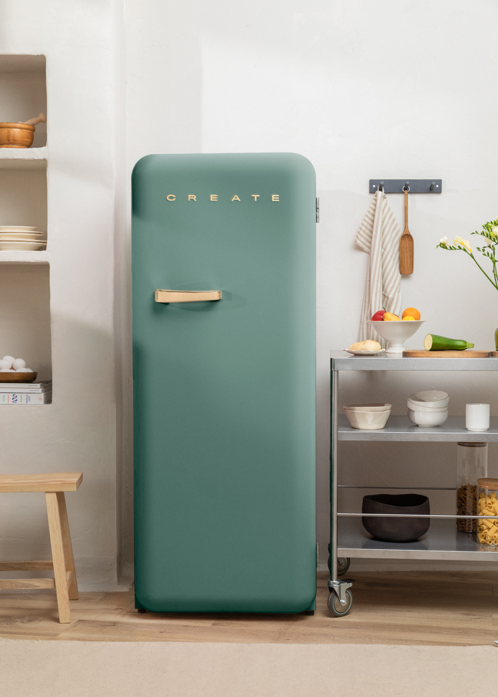 Un refrigerador verde azulado con 'CREATE', junto a un carrito de cocina.