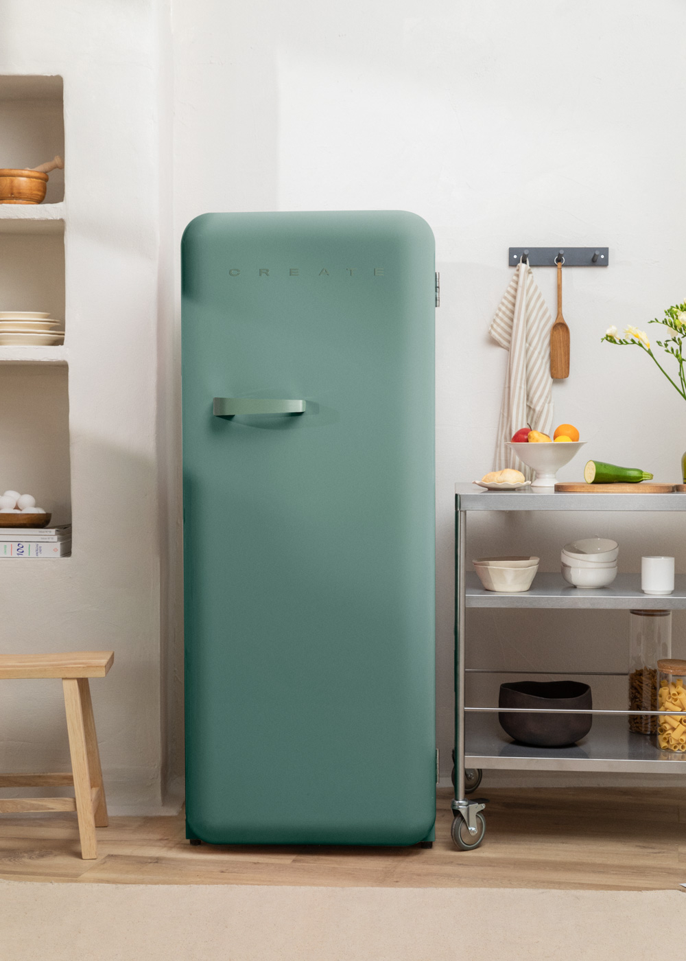 Un refrigerador verde retro está en una cocina. Frutas y verduras están en un carrito.