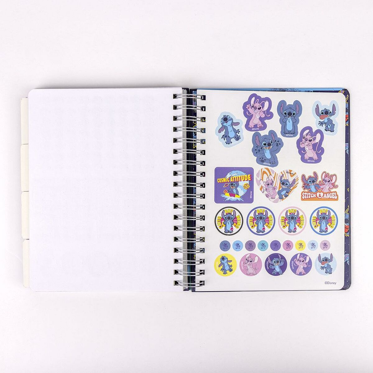Un cuaderno abierto con espiral con pegatinas de Stitch y páginas en blanco.