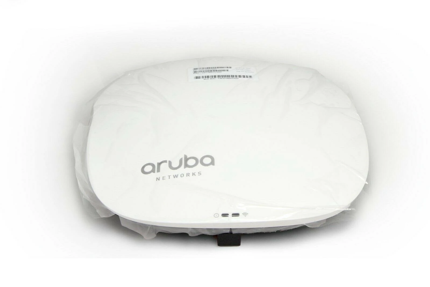 Białe urządzenie Aruba Networks, zakryte przezroczystą folią.