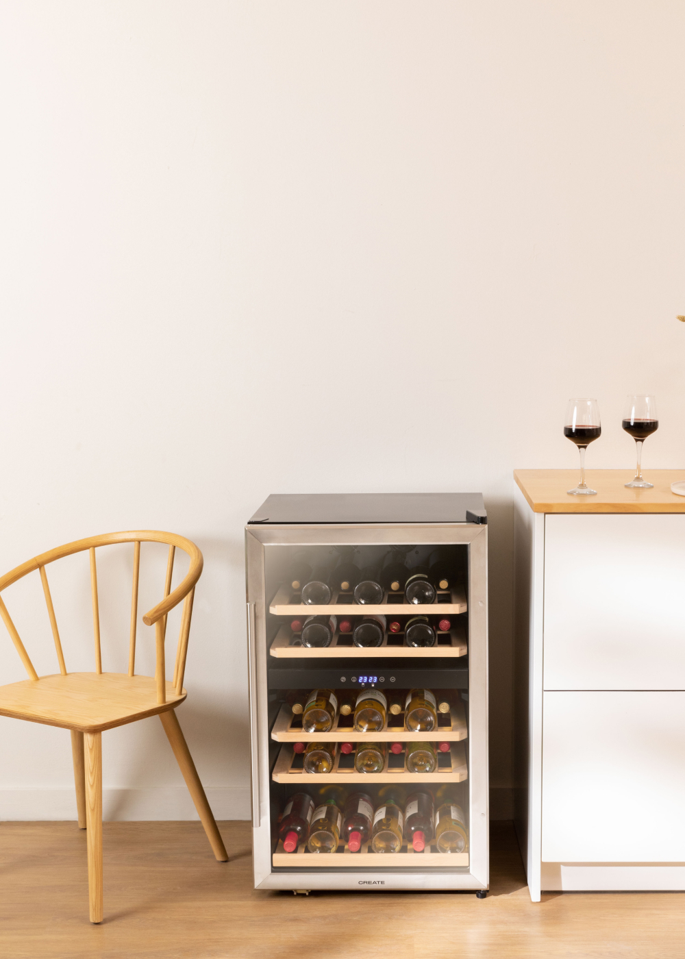 Vinoteca con botellas de vino. Dos copas de vino en una mesa de madera.