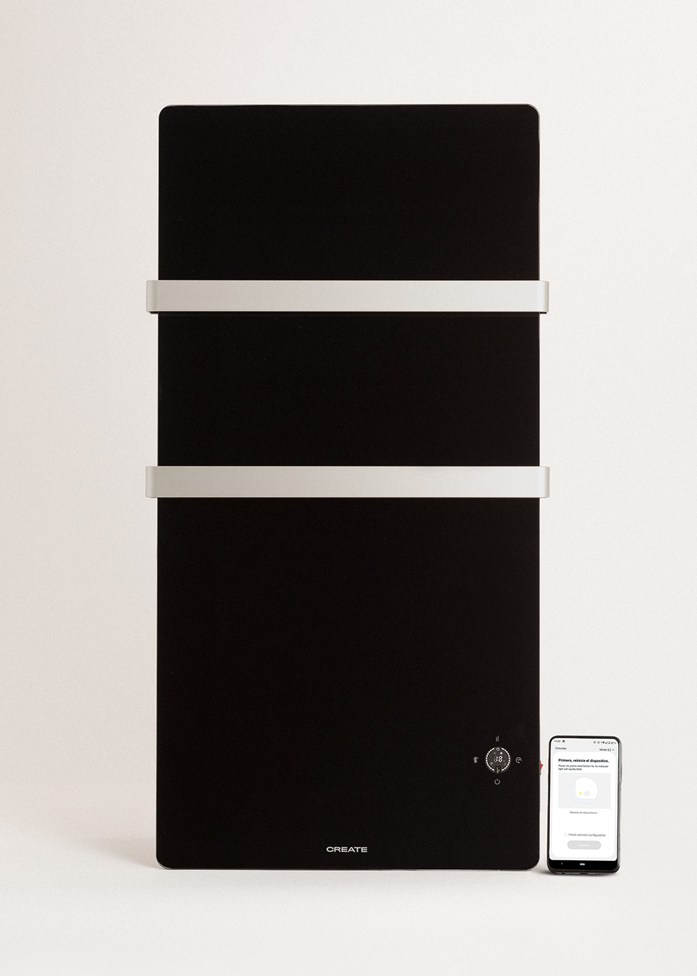 Un calefactor vertical negro con dos barras blancas. Un smartphone muestra ajustes junto a él.