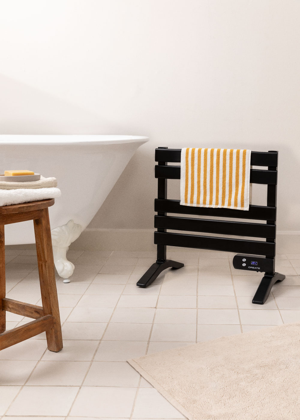 Toallero negro con toalla a rayas amarillas en un baño con bañera.