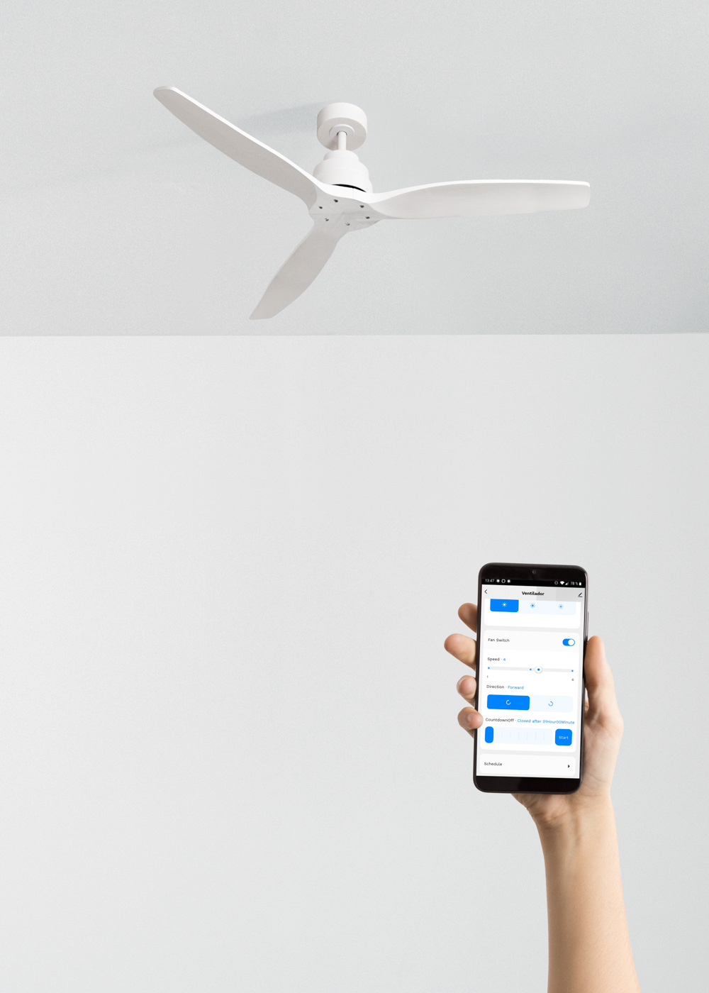 Ventilador de techo blanco con tres aspas. Mano sosteniendo un teléfono con una app.