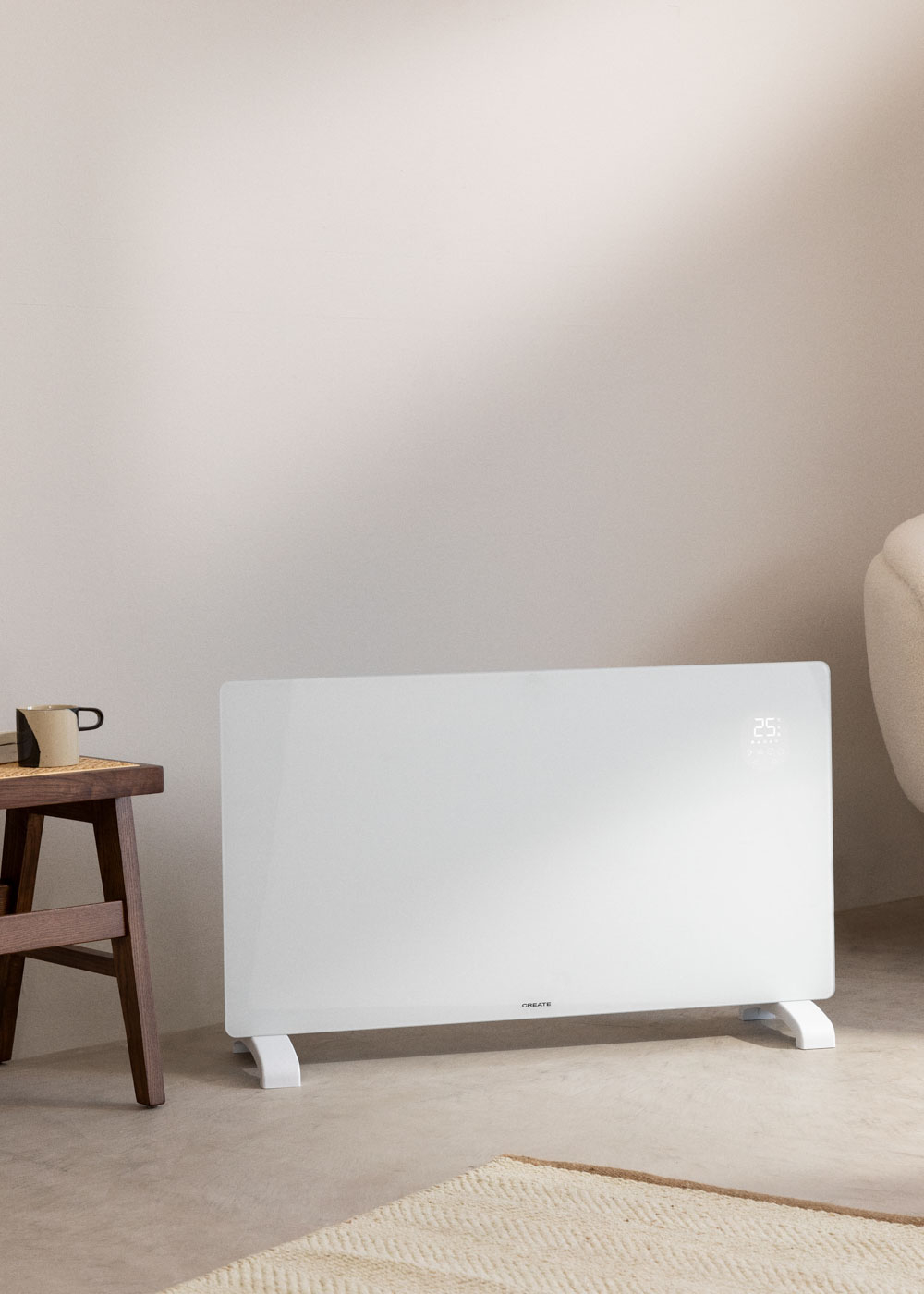 Un calefactor de panel CREATE blanco con pantalla digital. Está en una habitación con un taburete.