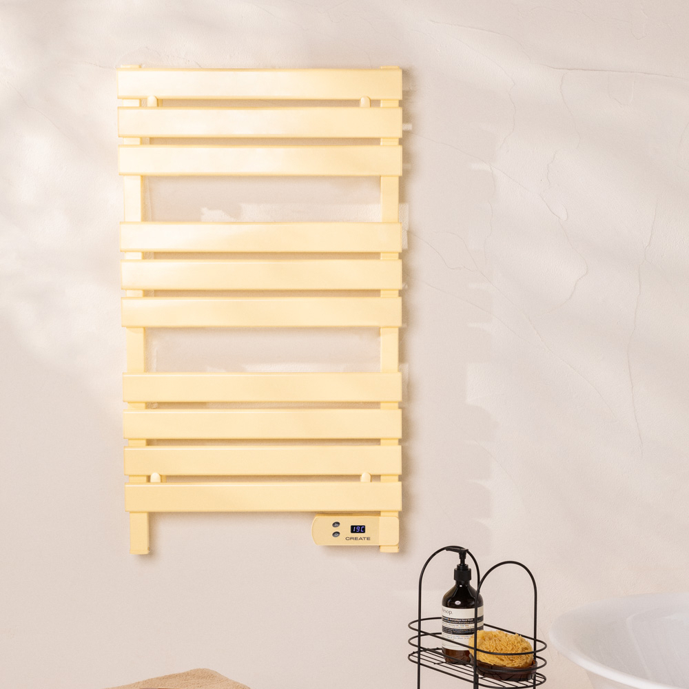 Toallero eléctrico amarillo en una pared blanca. Accesorios negros debajo. Etiqueta CREATE.