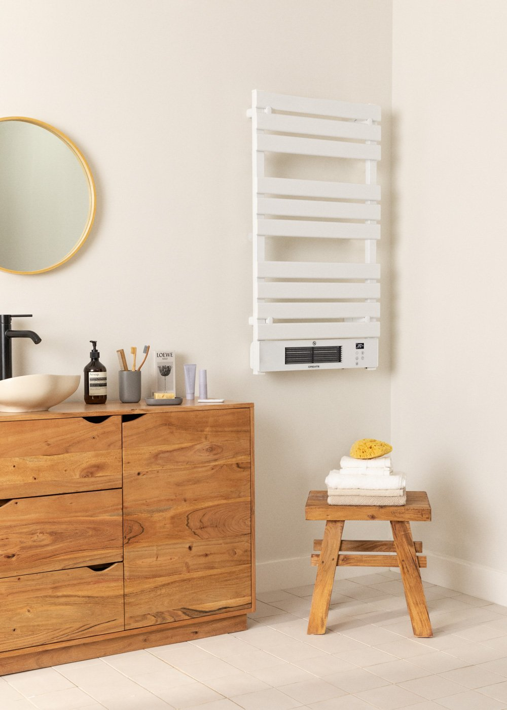 Baño moderno con un mueble de madera, espejo y un toallero. Hay artículos de tocador en el mueble.
